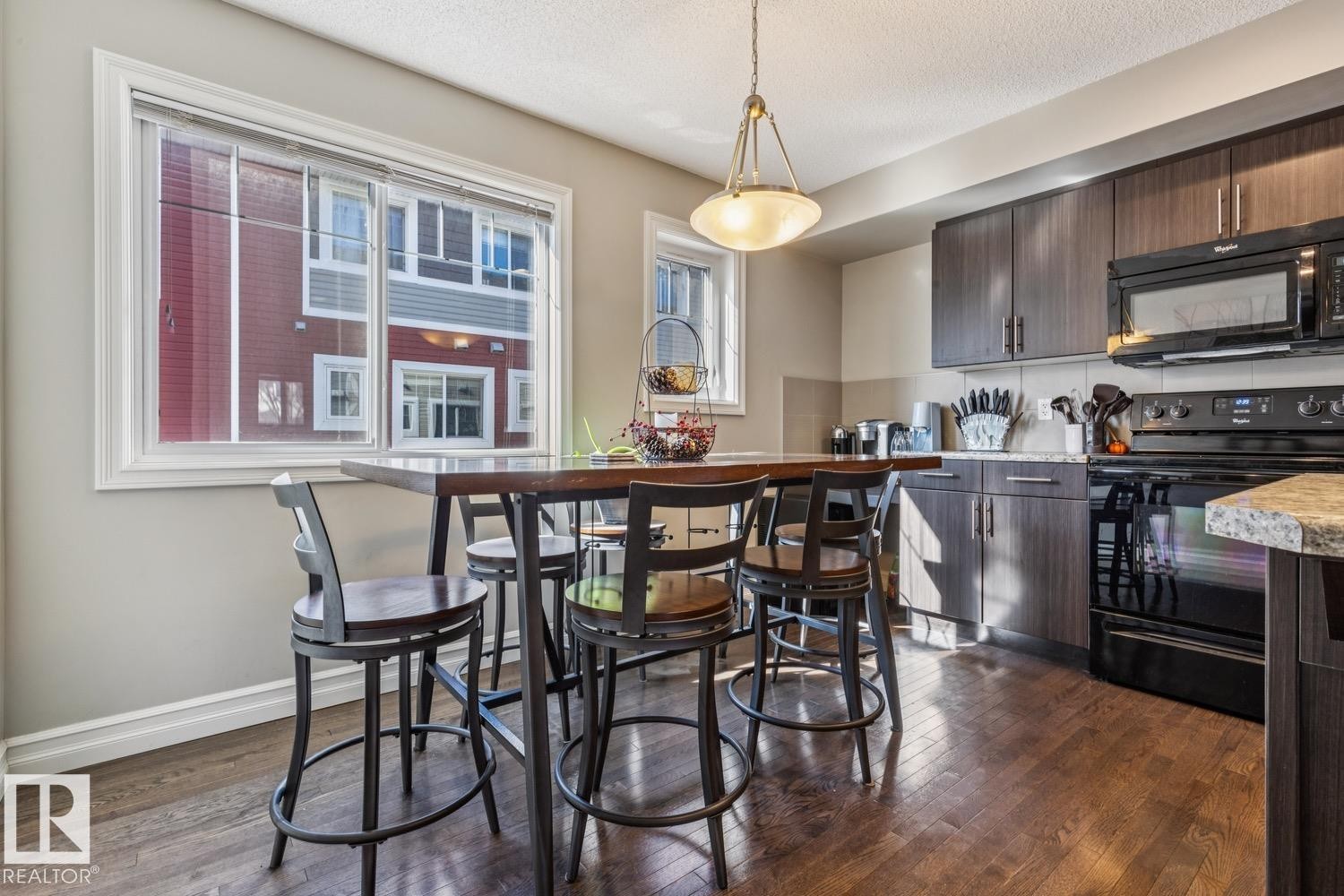 Dining area with dark wood finished floors and a textured ceiling - 5409 3 Avenue, Edmonton, AB - Indoor Photo Showing Kitchen
