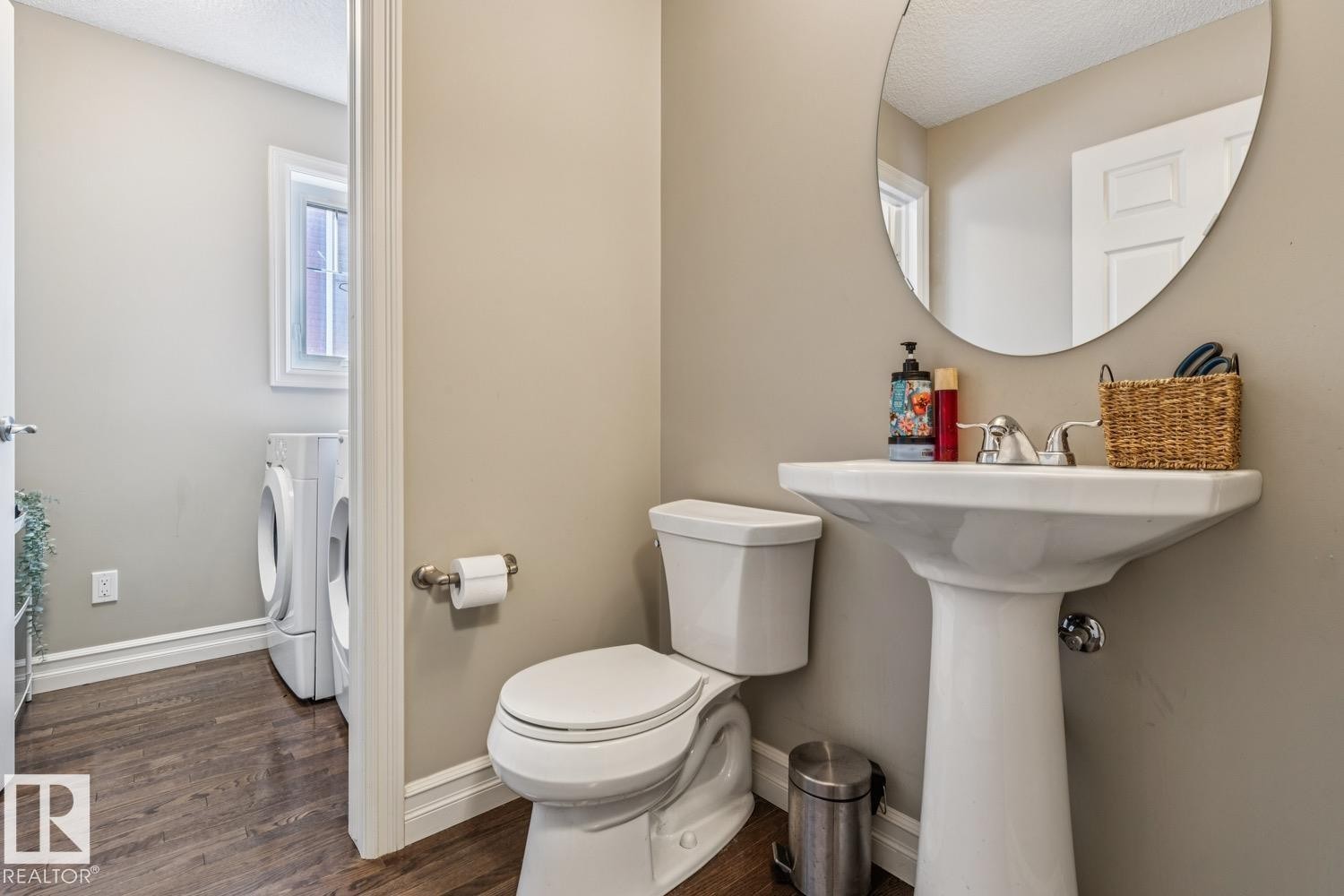 Half bathroom with washing machine and clothes dryer, dark wood-style flooring, and a textured ceiling - 5409 3 Avenue, Edmonton, AB - Indoor Photo Showing Bathroom