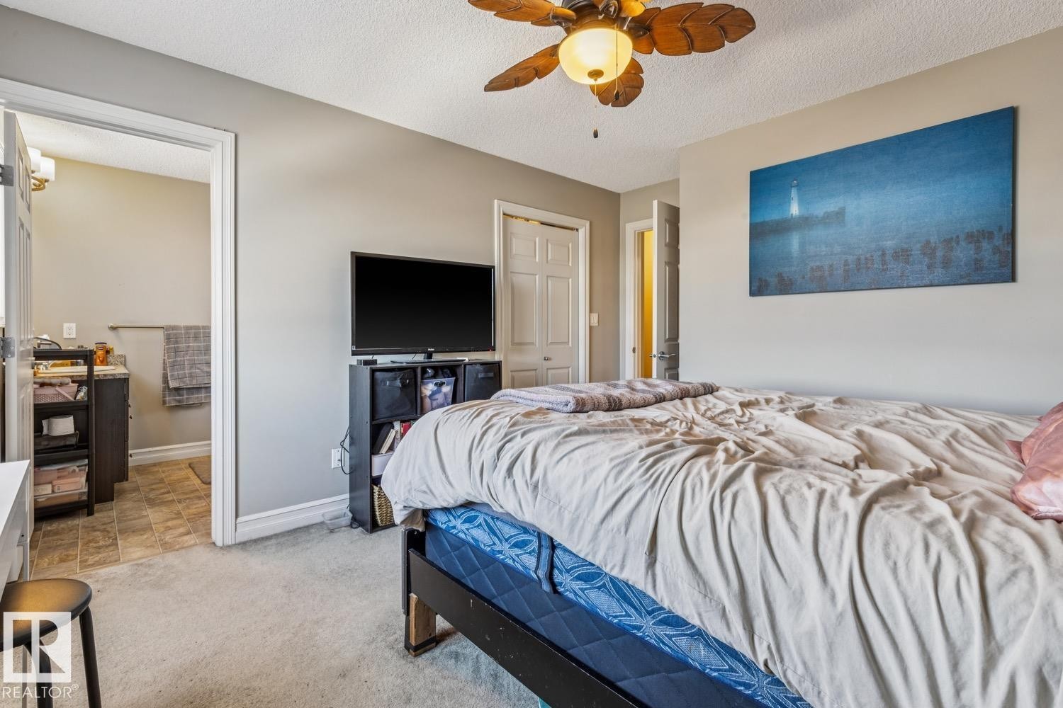 Bedroom with a textured ceiling, ceiling fan, light colored carpet, and a closet - 5409 3 Avenue, Edmonton, AB - Indoor Photo Showing Bedroom