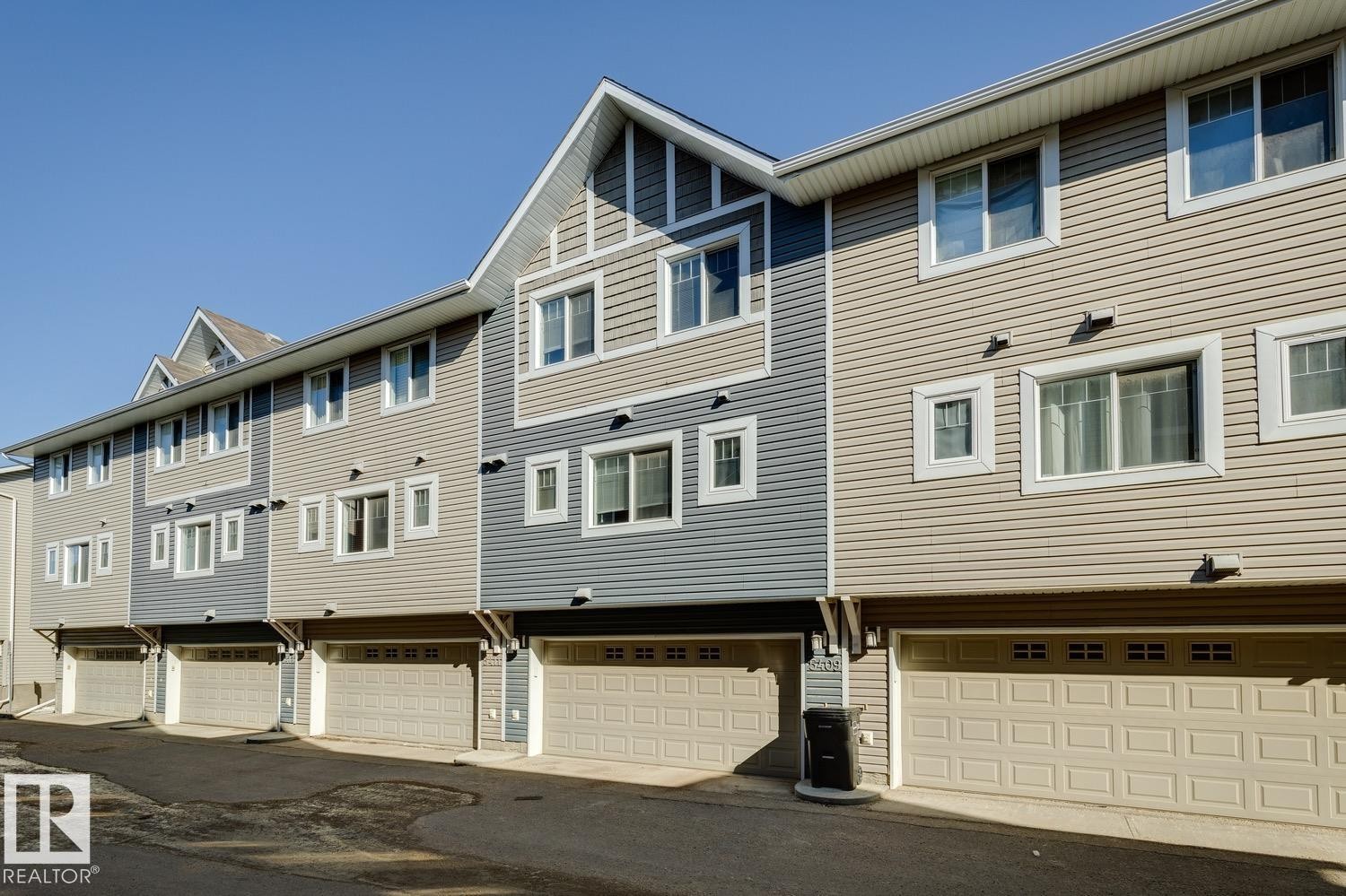 Back of house featuring an attached garage and a residential view - 5409 3 Avenue, Edmonton, AB - Outdoor