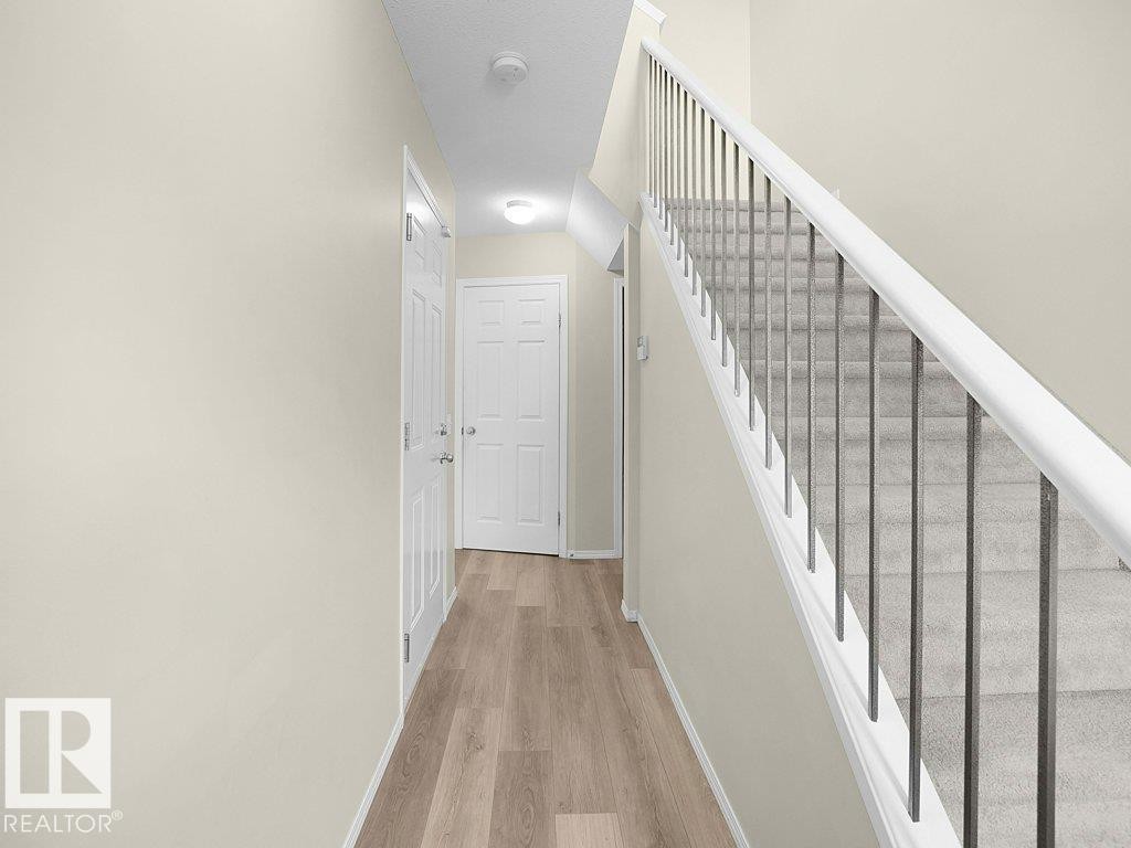 Stairway with baseboards and wood finished floors - 196 230 Edwards Drive, Edmonton, AB - Indoor Photo Showing Other Room