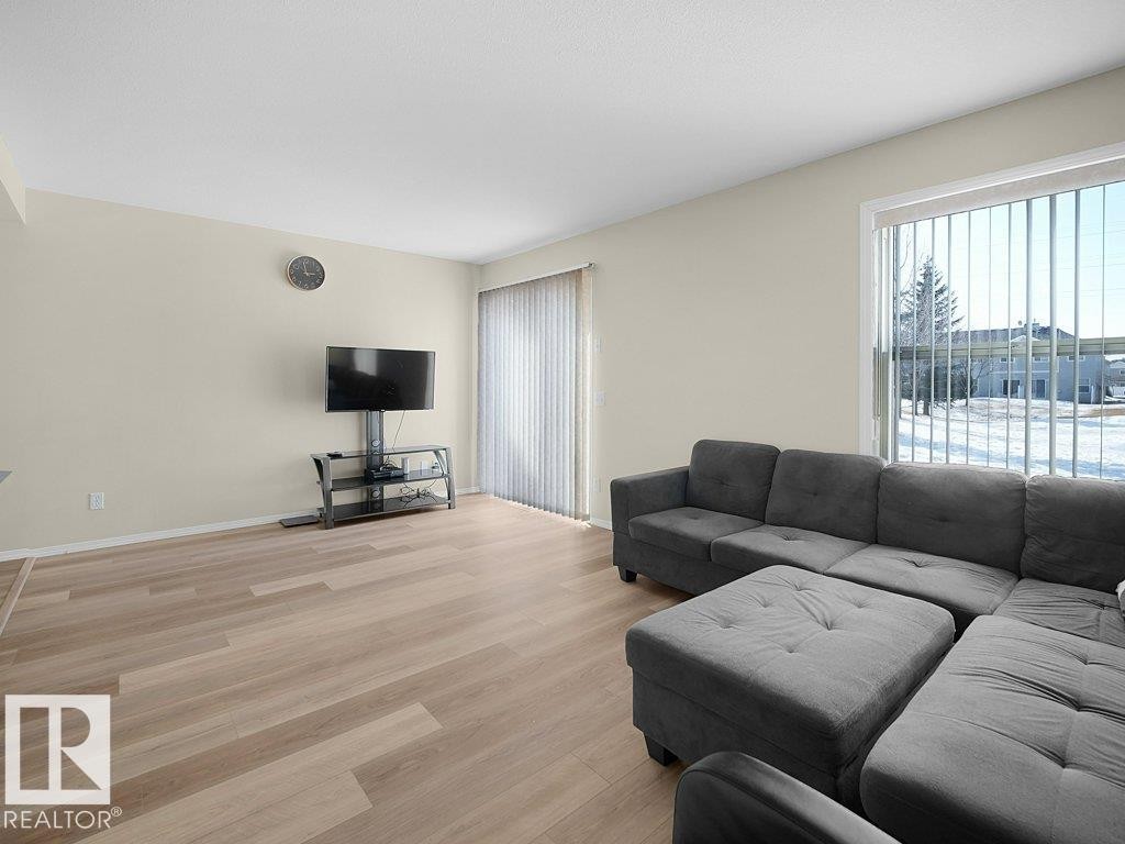 Living area with light wood-style floors and baseboards - 196 230 Edwards Drive, Edmonton, AB - Indoor Photo Showing Living Room