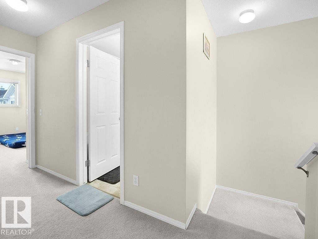 Corridor featuring light colored carpet and baseboards - 196 230 Edwards Drive, Edmonton, AB - Indoor Photo Showing Other Room