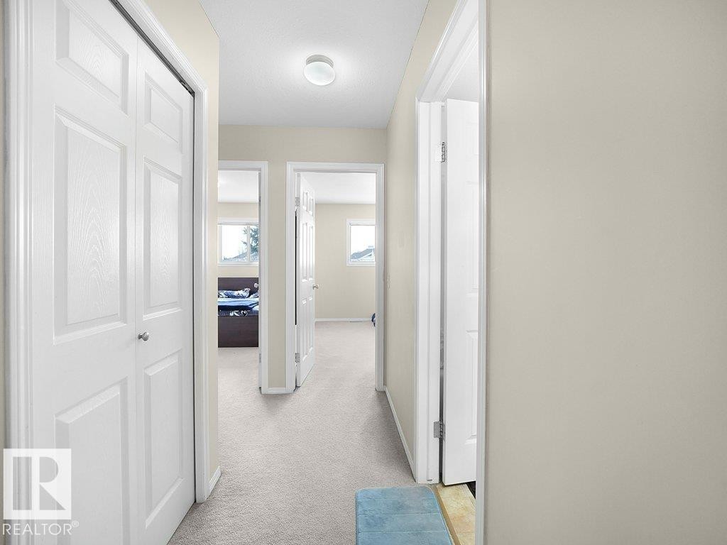Hall featuring baseboards and light carpet - 196 230 Edwards Drive, Edmonton, AB - Indoor Photo Showing Other Room