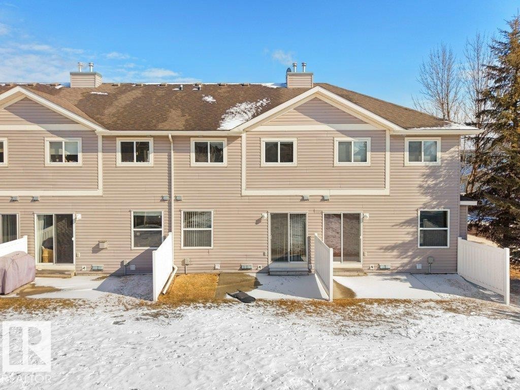 Snow covered back of property featuring a patio and a chimney - 196 230 Edwards Drive, Edmonton, AB - Outdoor