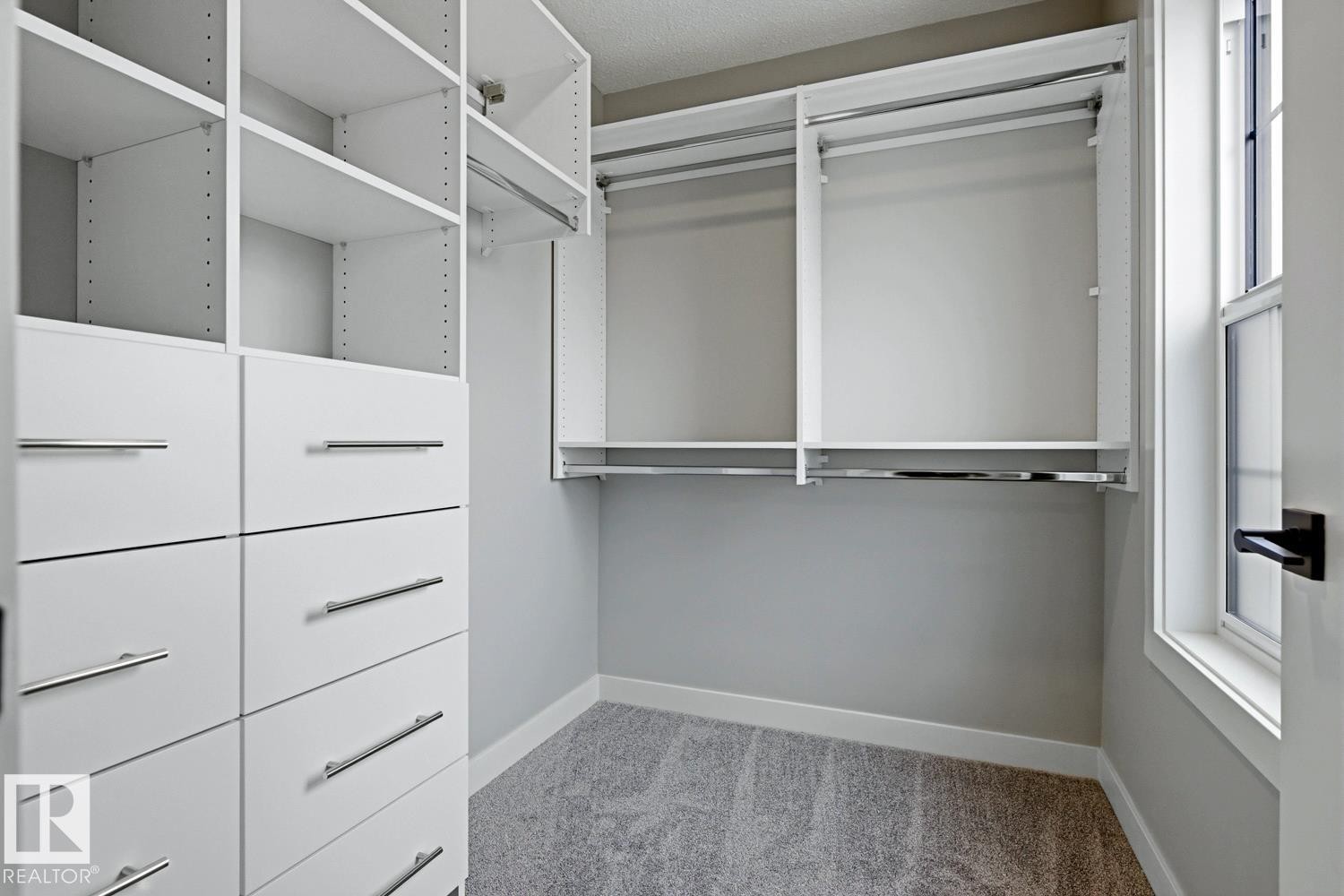 Custom closet system featuring white cabinetry, multiple shelving units, integrated drawers with brushed nickel hardware, and dual hanging rods - 30 Chartres Close Nw, St. Albert, AB