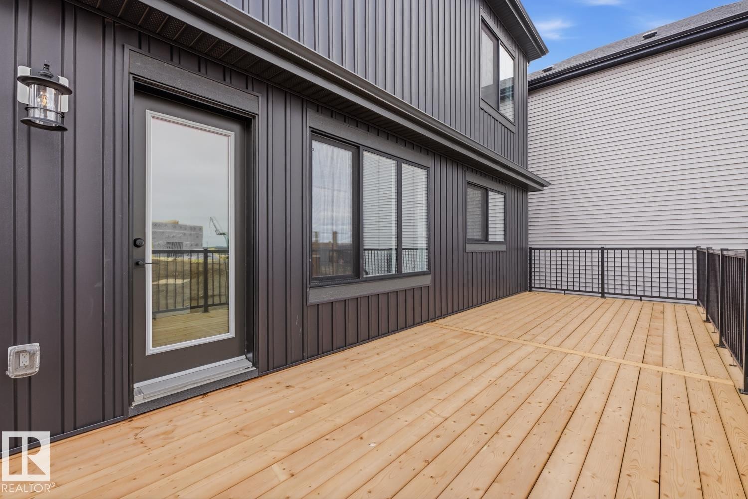 Expansive outdoor deck featuring natural wood decking and black metal railing - 30 Chartres Close Nw, St. Albert, AB
