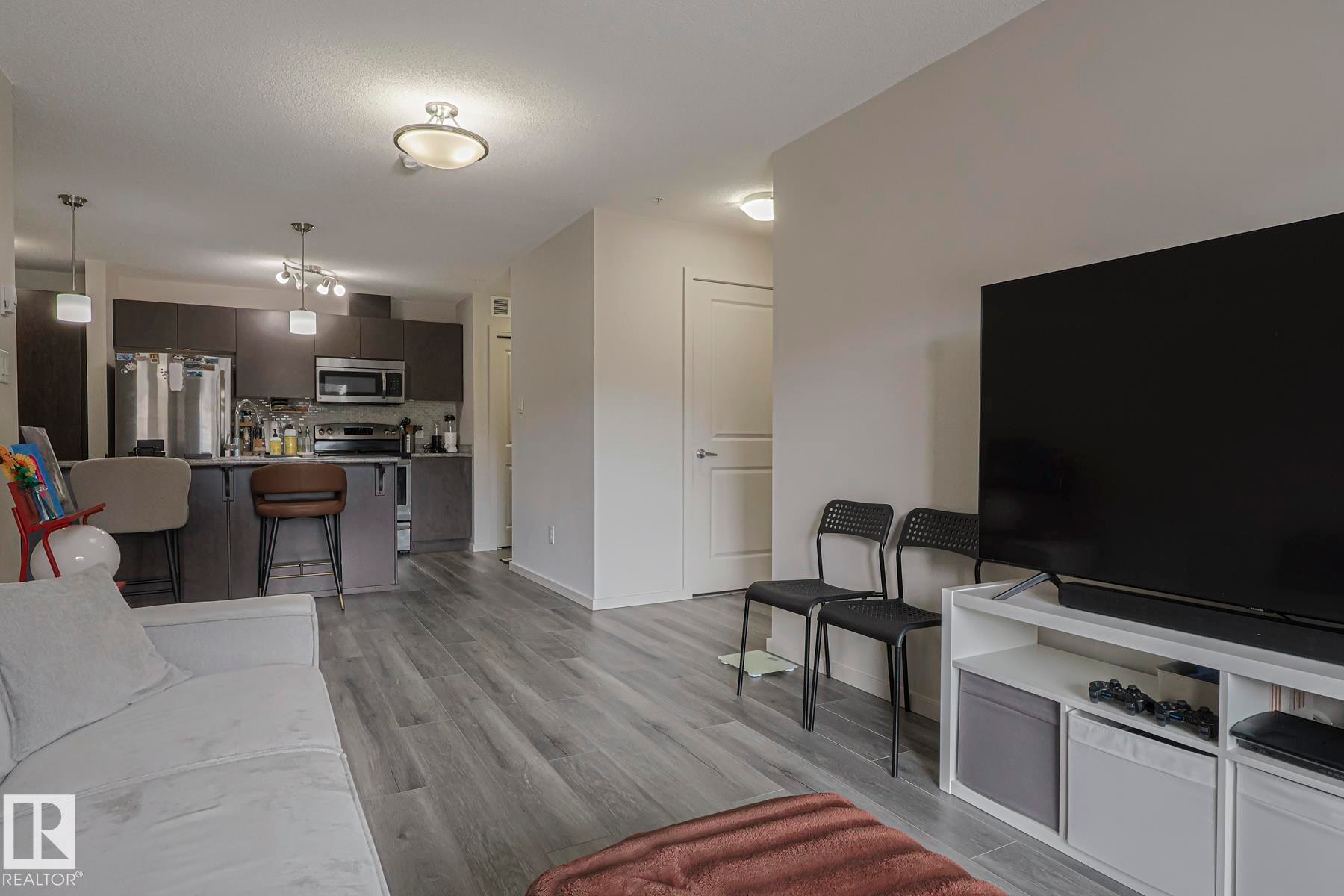 Living room with light wood-style flooring and baseboards - 236 344 Windermere Road, Edmonton, AB - Indoor