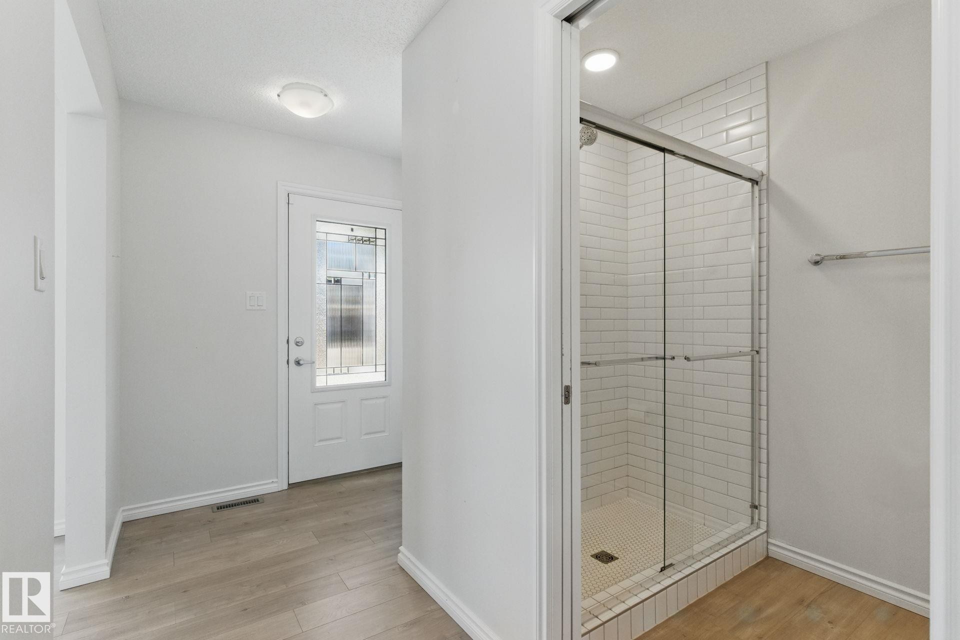 The entrance features light-colored flooring and a white door with decorative glass inserts - 2416 Wonnacott Crest Sw, Edmonton, AB - Indoor Photo Showing Other Room