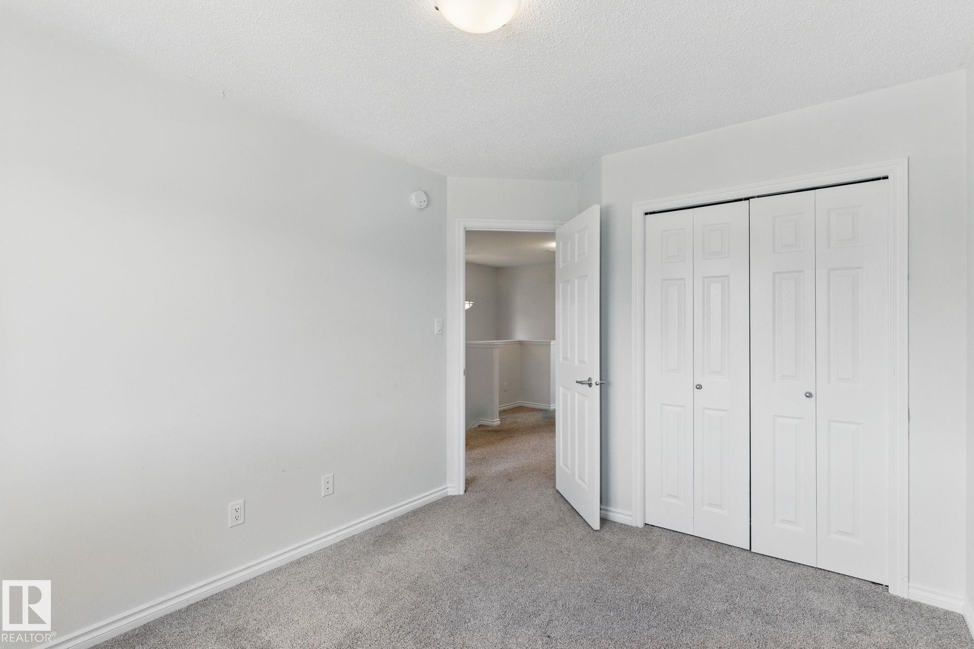 This room features light grey walls, grey carpet flooring, and a ceiling light fixture - 2416 Wonnacott Crest Sw, Edmonton, AB - Indoor