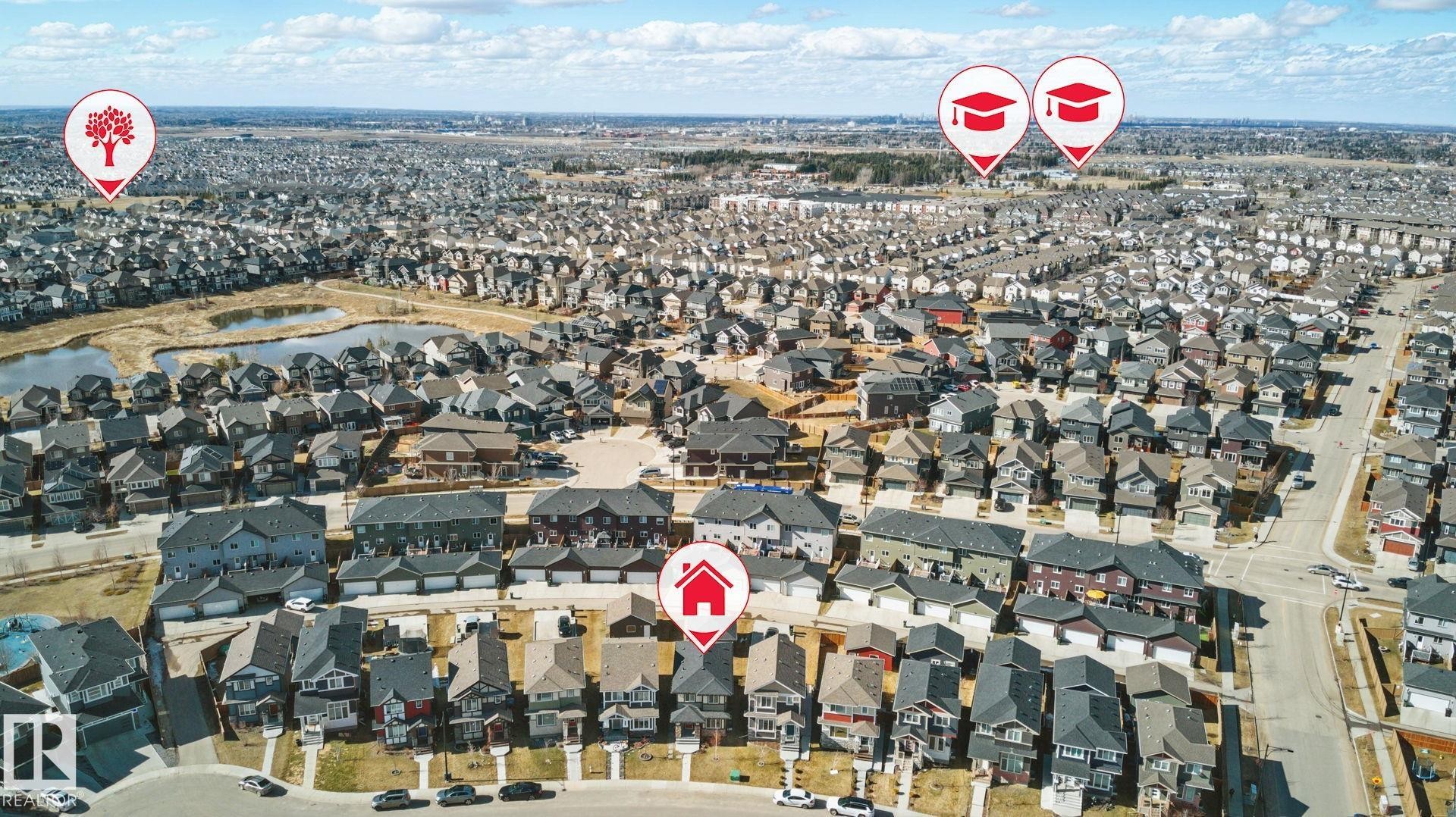 Aerial view of the neighborhood showcasing residential properties, a nearby pond, and accessible roads - 2416 Wonnacott Crest Sw, Edmonton, AB - Outdoor With View