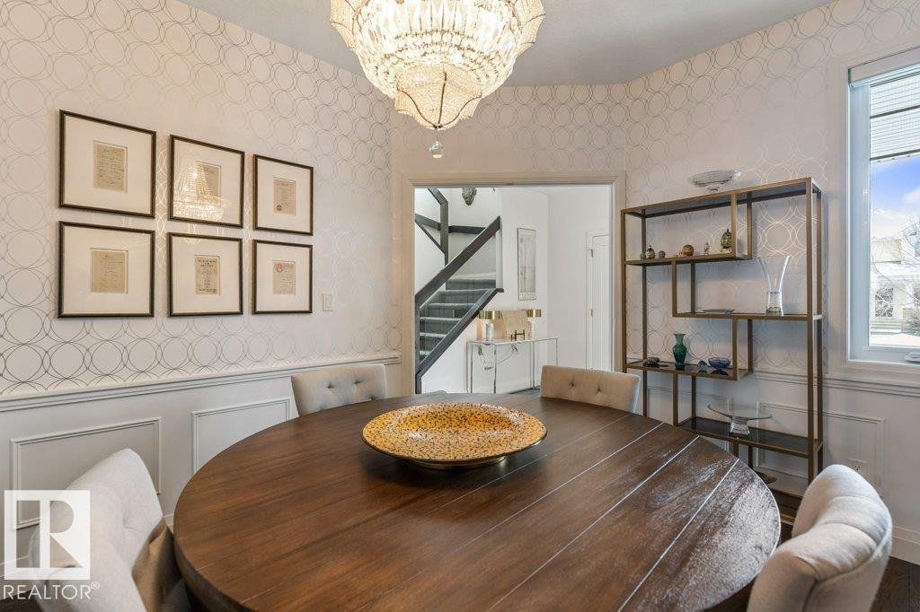 Formal Dining Room featuring Imported French Empire Chandelier, Wainscotting, and South Facing Window (Could be transitioned into a bedroom by reinstalling original doors) - 4476 Suzanna Crescent, Edmonton, AB - Indoor Photo Showing Dining Room