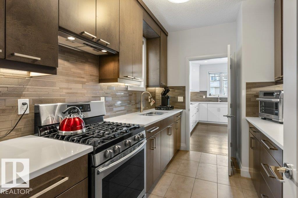 Secondary Main Floor Kitchen featuring Gas Stove, ample cabinet and counter space, and additional sink - 4476 Suzanna Crescent, Edmonton, AB - Indoor Photo Showing Kitchen With Upgraded Kitchen