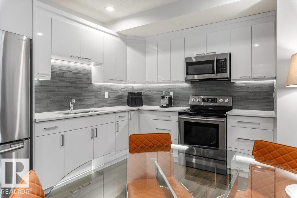 Basement Kitchen (Third Kitchen in the House) featuring Stainless Steel Appliances, White Cabinets, White Quartz Counters, and Tile Backsplash - 4476 Suzanna Crescent, Edmonton, AB - Indoor Photo Showing Kitchen With Upgraded Kitchen