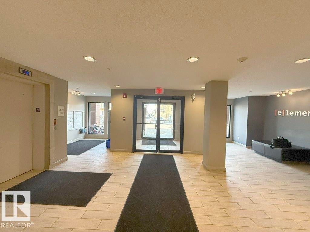 Entryway featuring light-toned tile flooring, recessed lighting, and a neutral color palette - 429 390 Windermere Rd, Edmonton, AB - Indoor Photo Showing Other Room