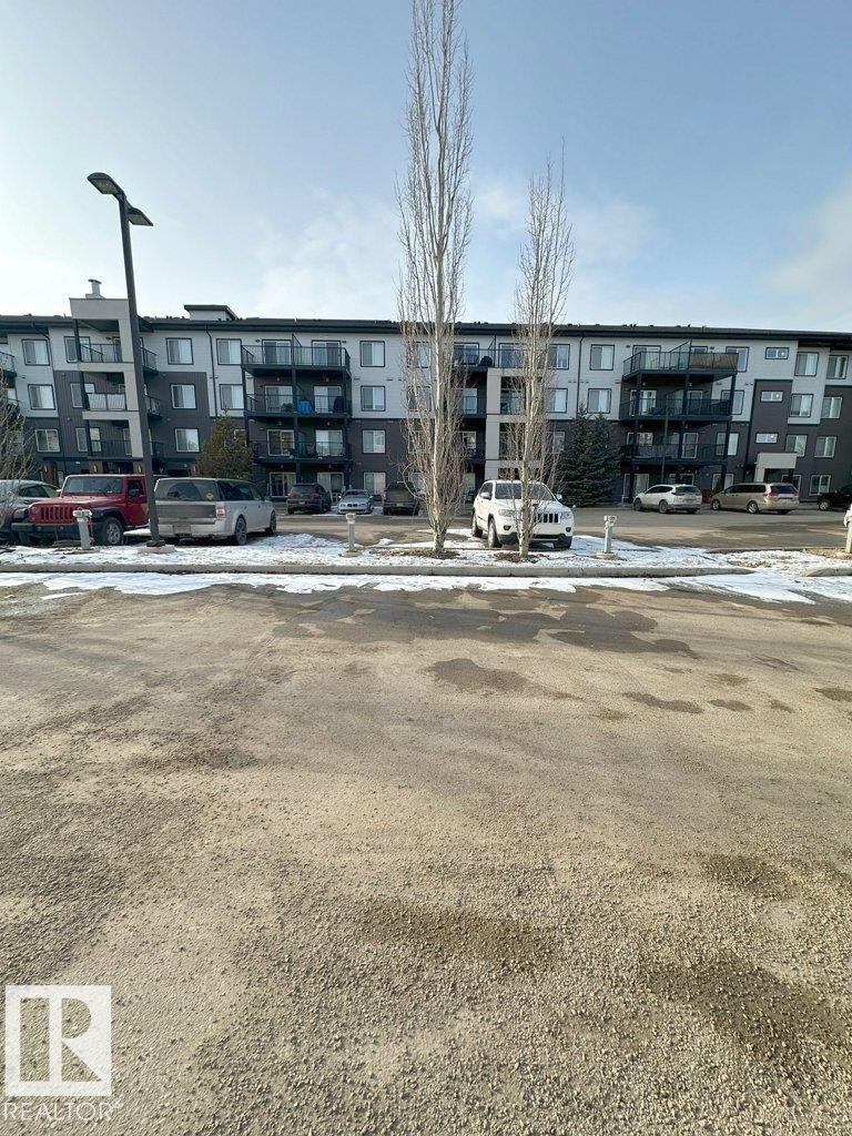 The property features a multi-story building with balconies, set against a clear sky - 429 390 Windermere Rd, Edmonton, AB - Outdoor