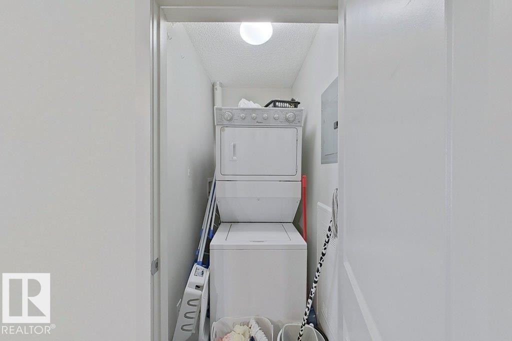 Dedicated laundry area featuring a stacked washer and dryer - 429 390 Windermere Rd, Edmonton, AB - Indoor Photo Showing Laundry Room