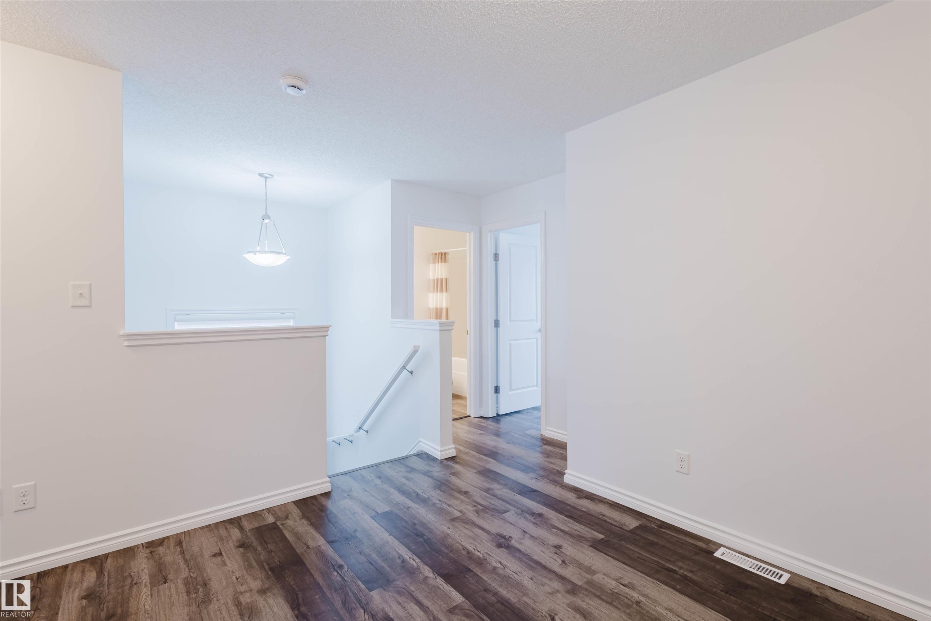 Unfurnished room featuring dark wood finished floors and a textured ceiling - Edmonton, AB - Indoor Photo Showing Other Room