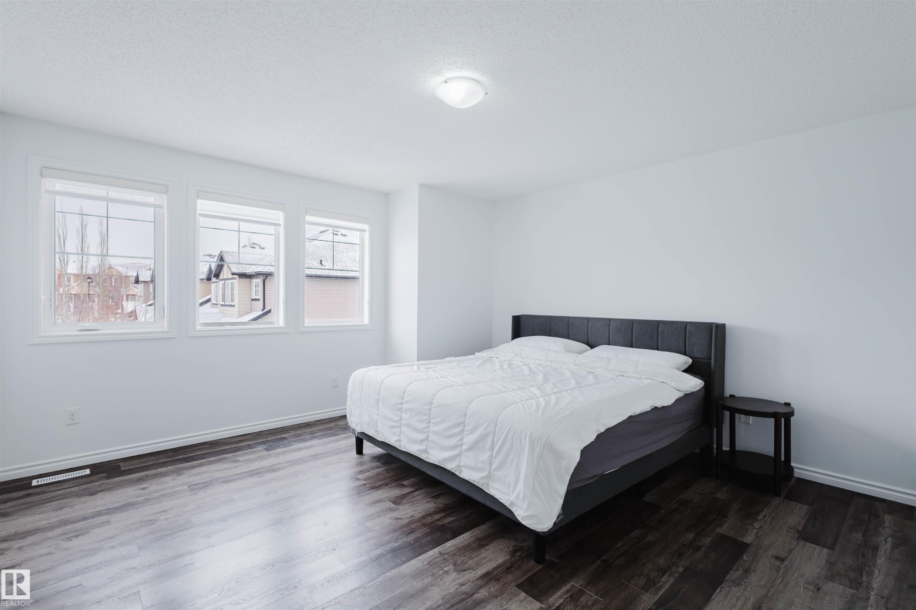 Bedroom featuring dark wood-style flooring and baseboards - Edmonton, AB - Indoor Photo Showing Bedroom