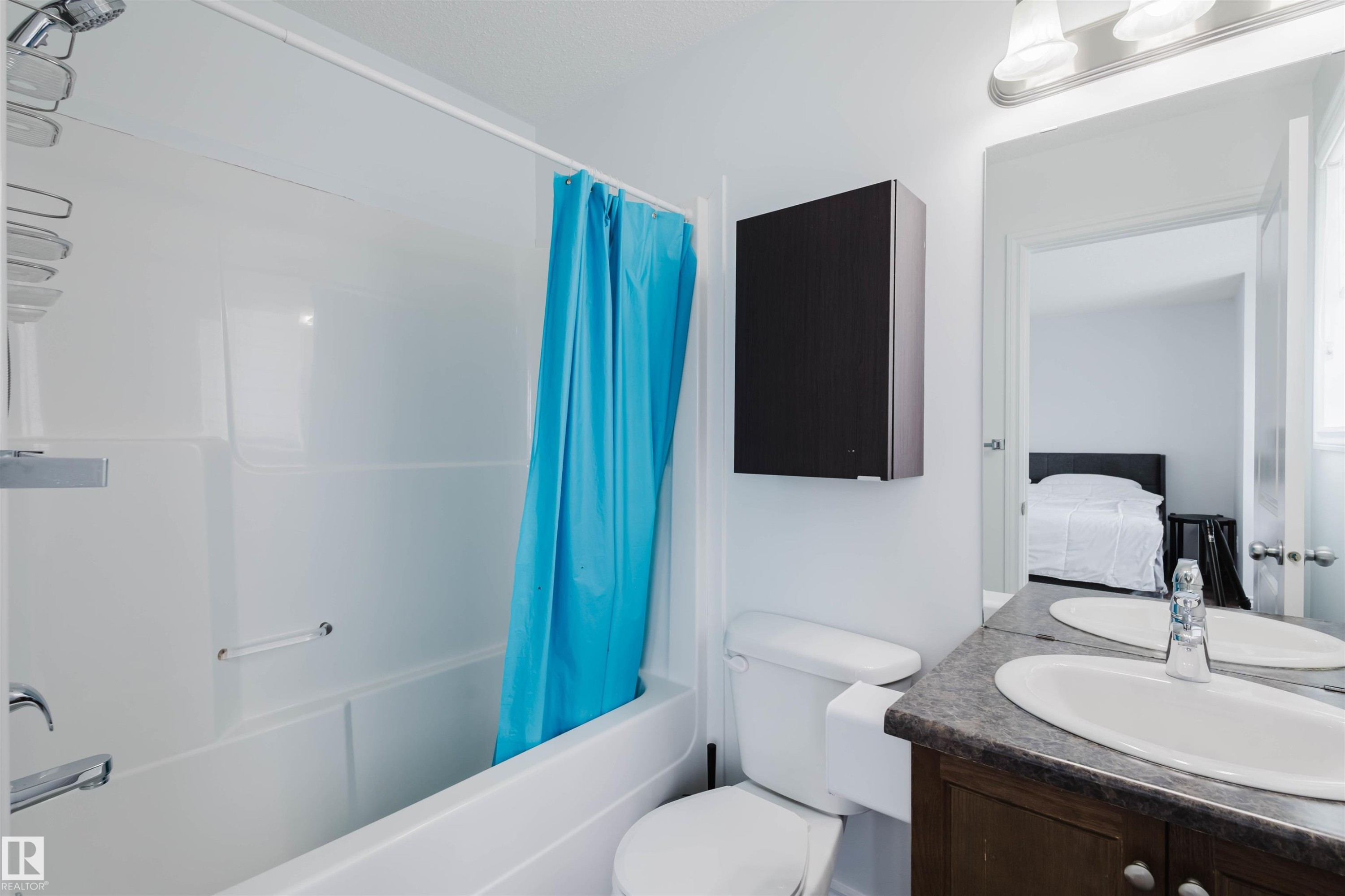 Ensuite bathroom featuring vanity and shower / bathtub combination with curtain - Edmonton, AB - Indoor Photo Showing Bathroom