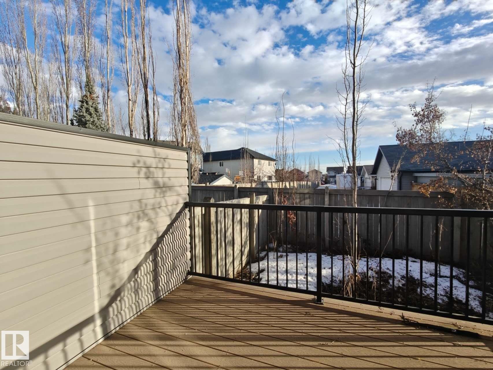 The property features an outdoor deck with a dark railing and a privacy wall - Edmonton, AB - Outdoor
