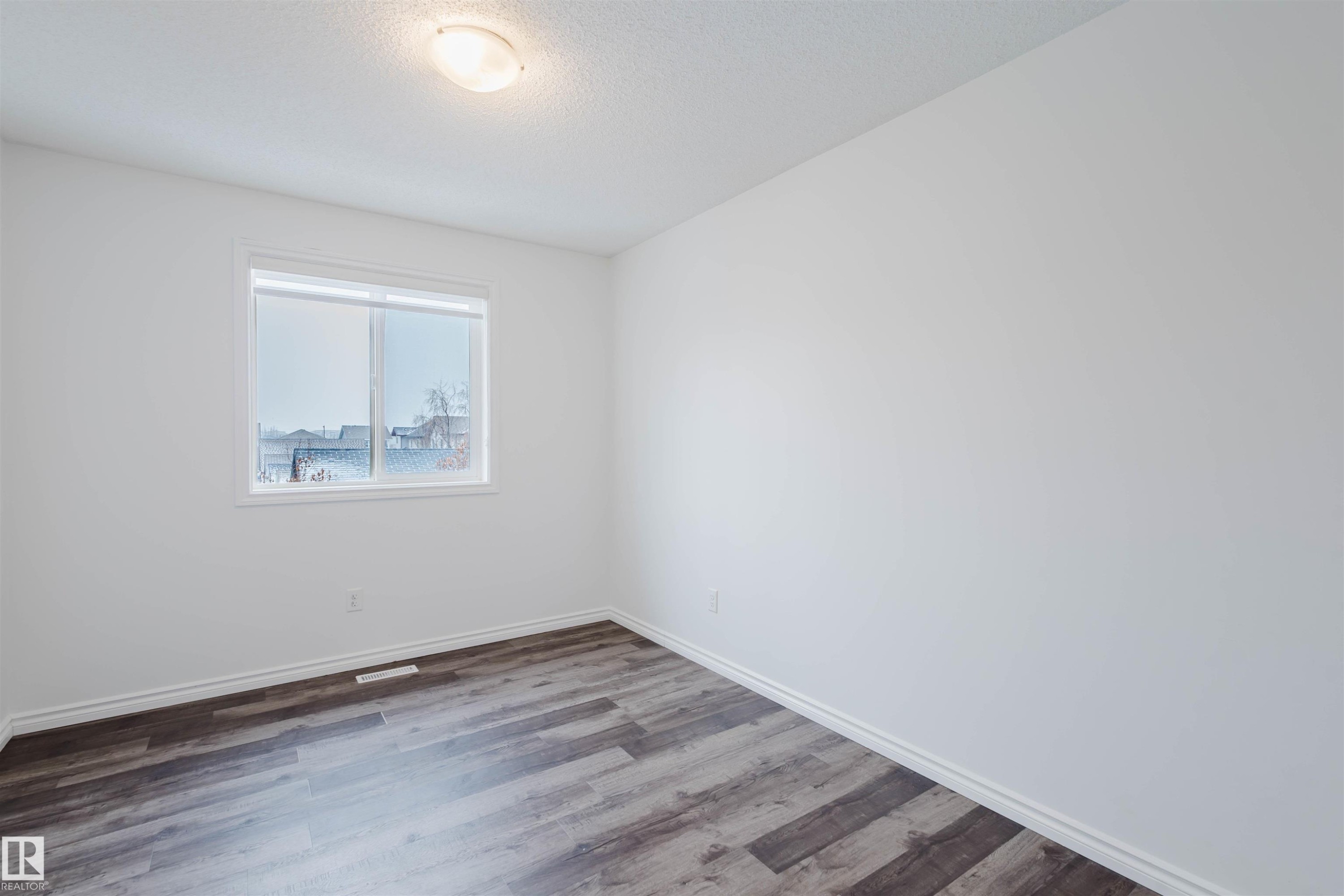 Unfurnished room featuring wood finished floors and a textured ceiling - Edmonton, AB - Indoor Photo Showing Other Room