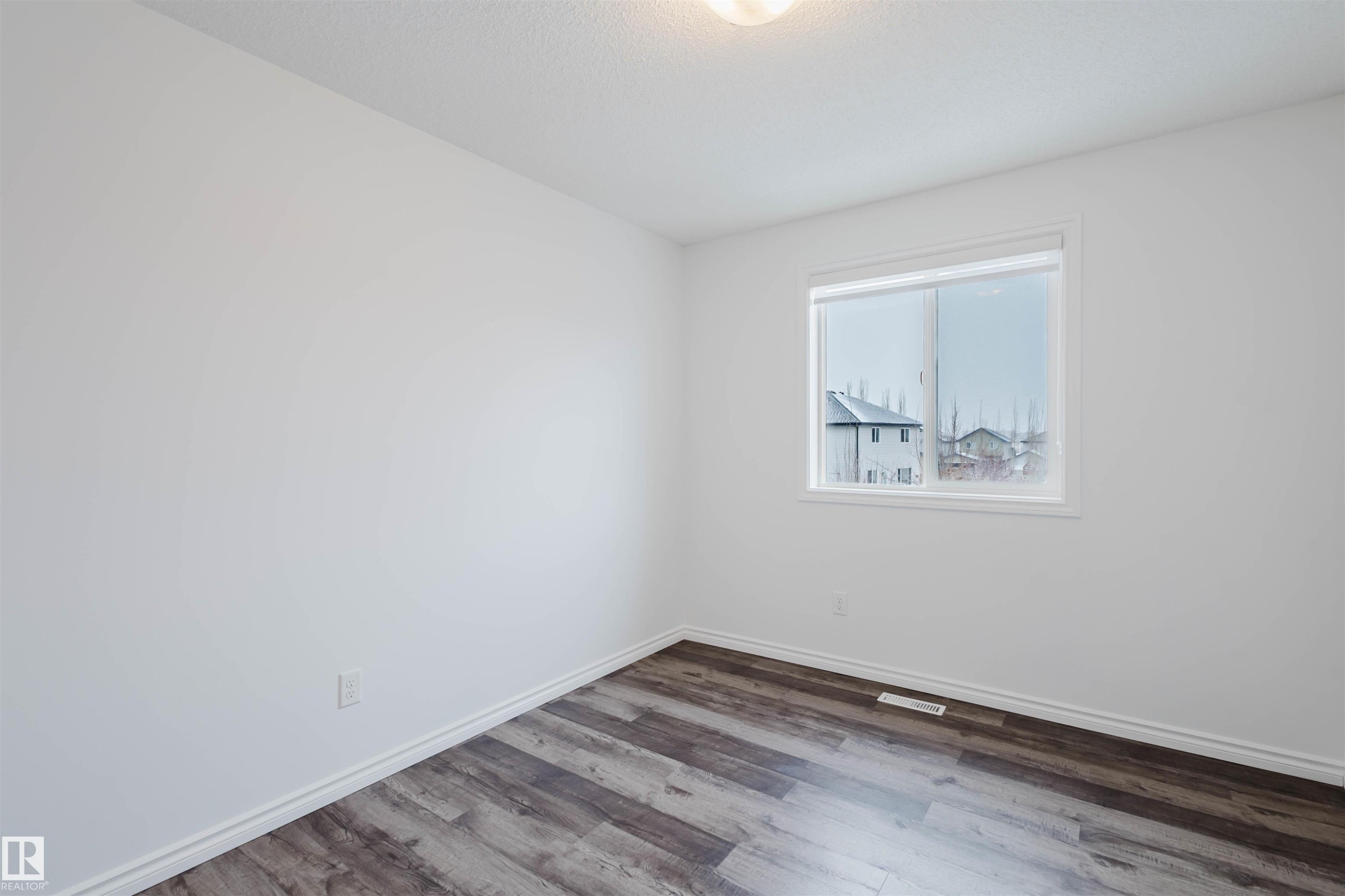 Empty room with light wood finished floors and a textured ceiling - Edmonton, AB - Indoor Photo Showing Other Room