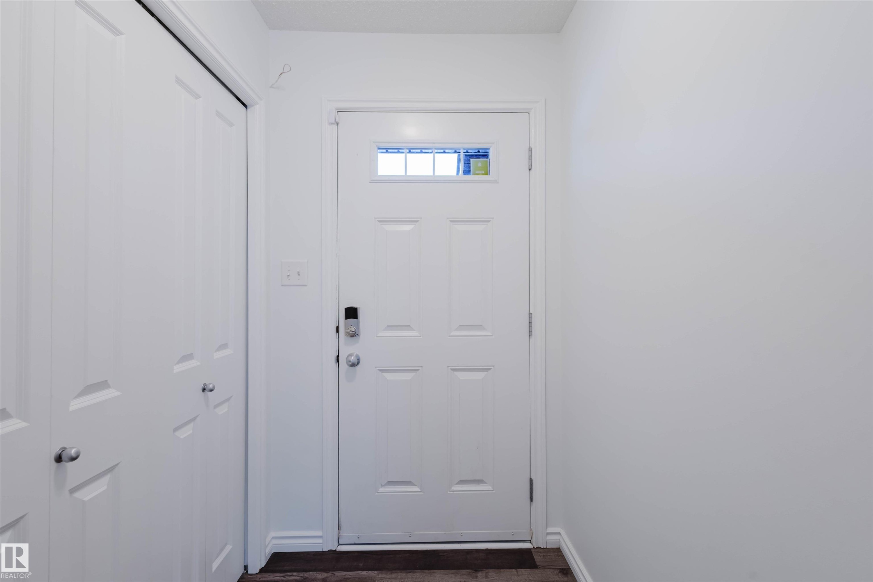 Doorway to outside with baseboards and wood finished floors - Edmonton, AB - Indoor Photo Showing Other Room
