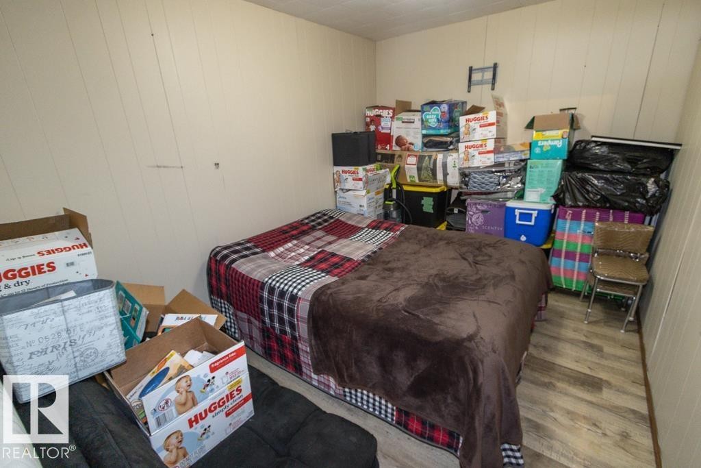 This room features paneled walls and wood-look flooring - 5016 47 St, Myrnam, AB - Indoor