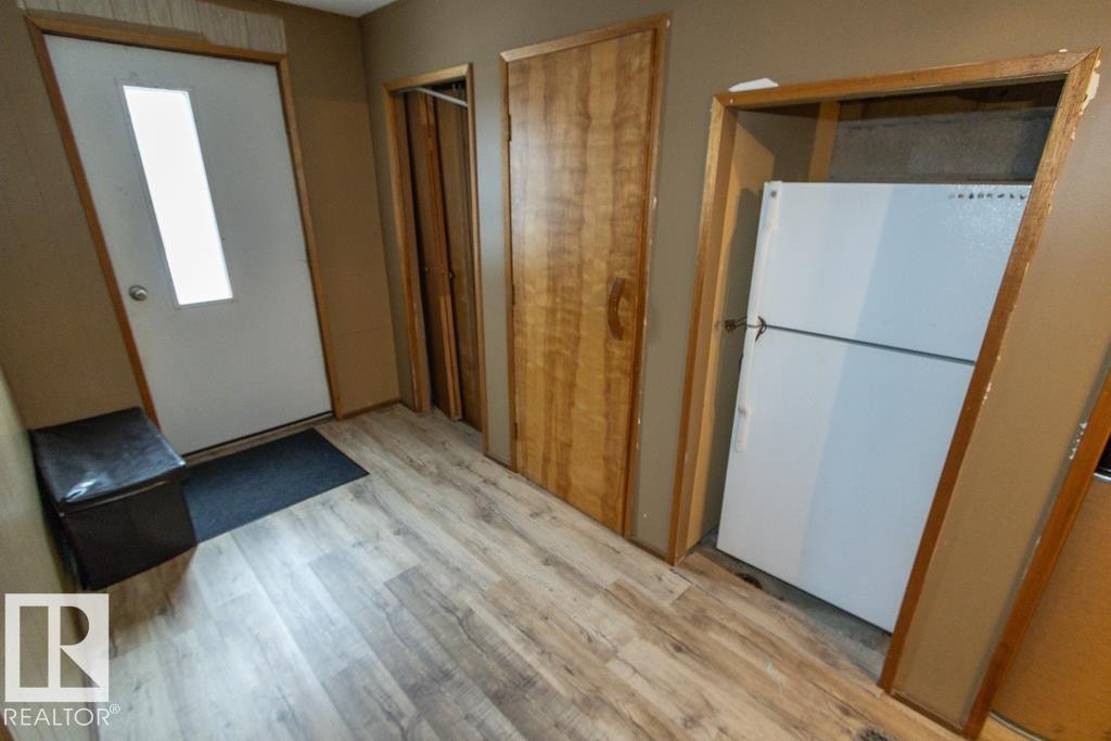 Entryway featuring light-toned flooring, a white door with a window, and a built-in refrigerator - 5016 47 St, Myrnam, AB - Indoor Photo Showing Other Room