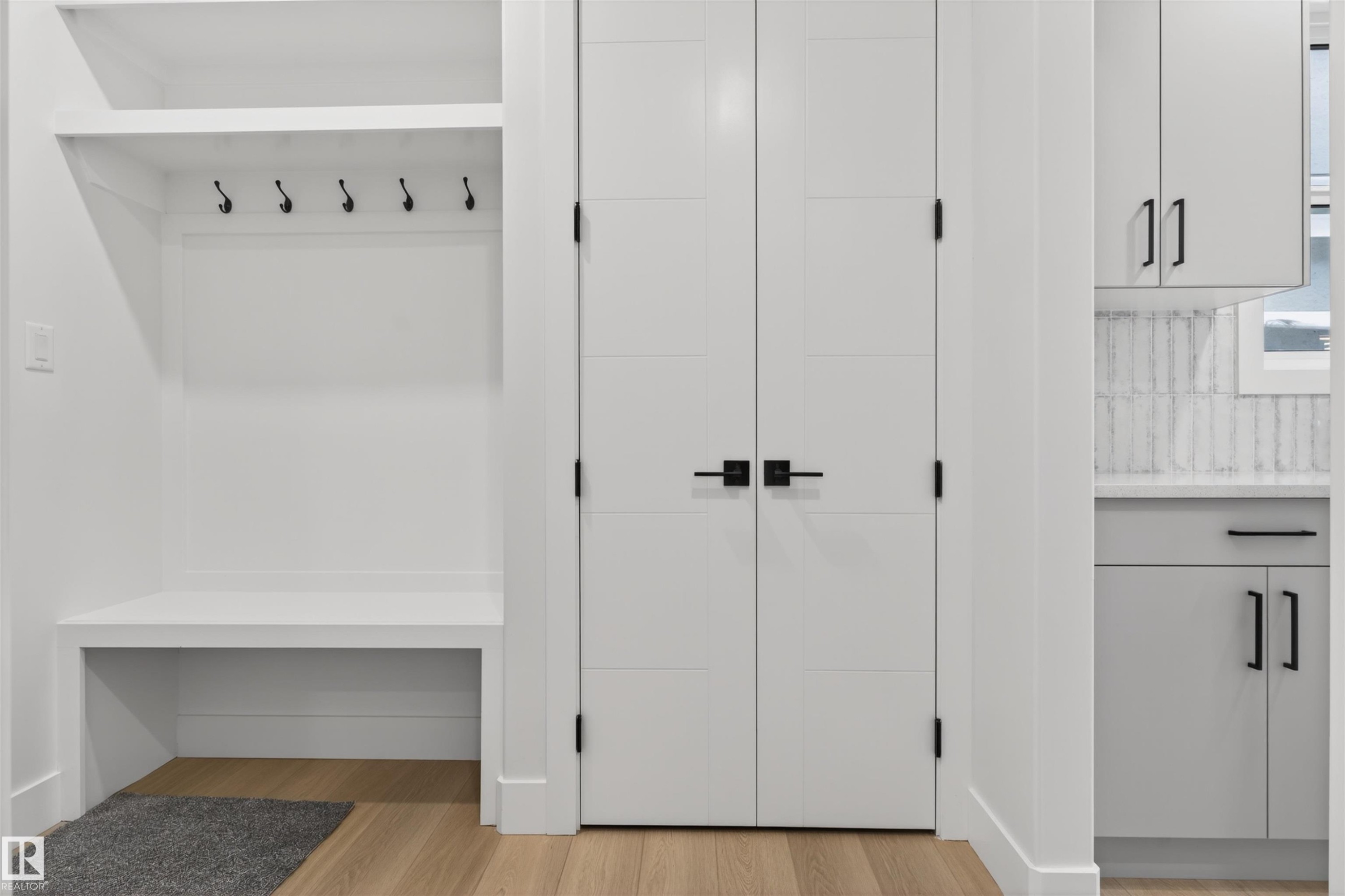 This entry area features a built-in bench and shelving with hooks, along with light wood flooring - 11 Redbud Way, St. Albert, AB - Indoor Photo Showing Other Room