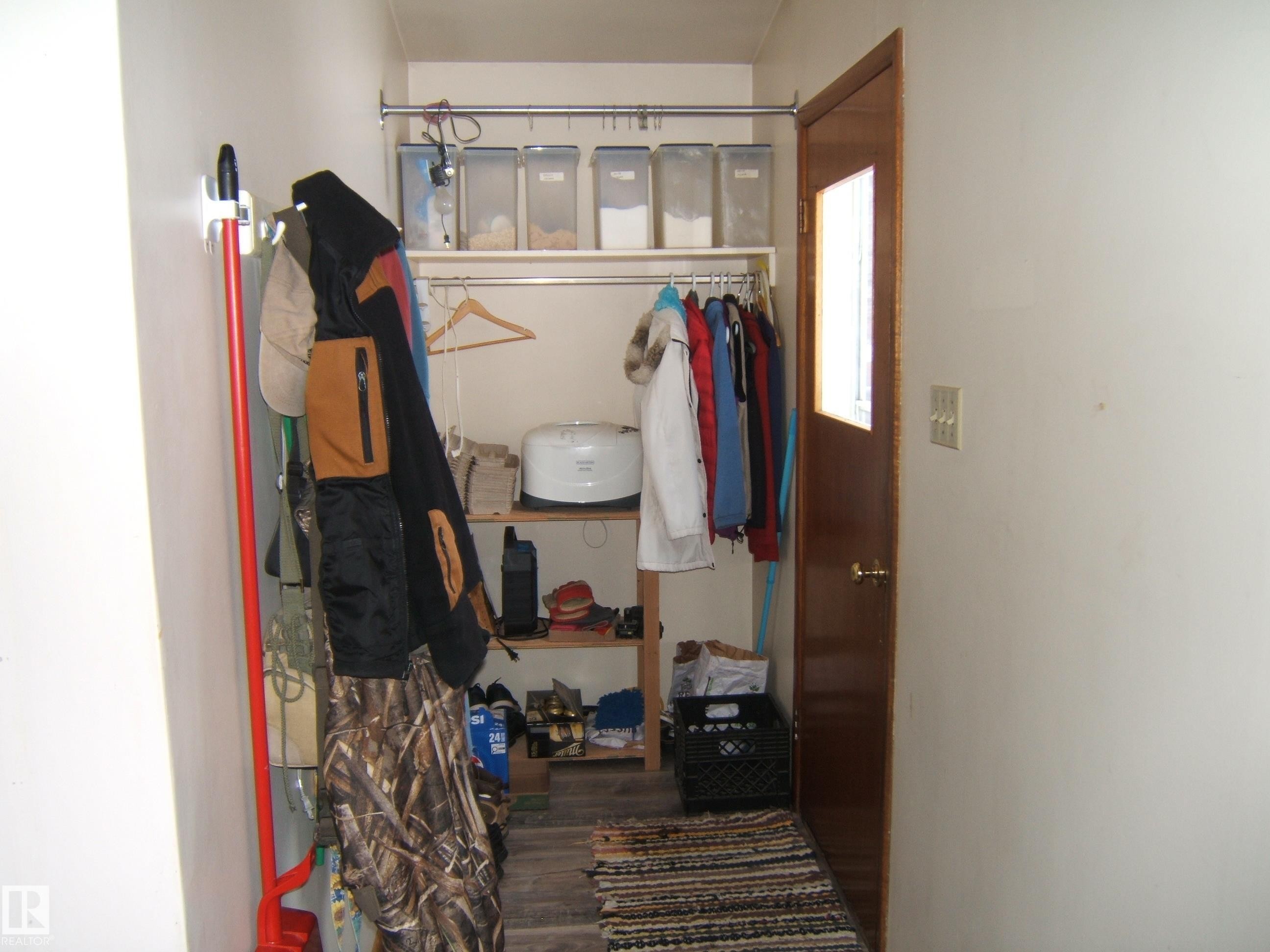 The entry area features a wood door with a window insert and a textured floor mat - 4702 52 Avenue, Two Hills, AB - Indoor