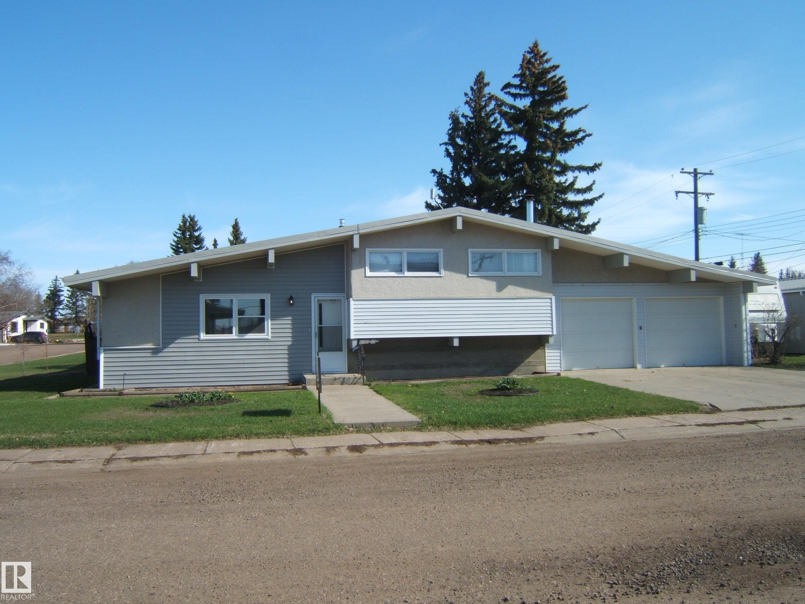 Split-level residence featuring a double attached garage and concrete driveway - 4702 52 Avenue, Two Hills, AB - Outdoor