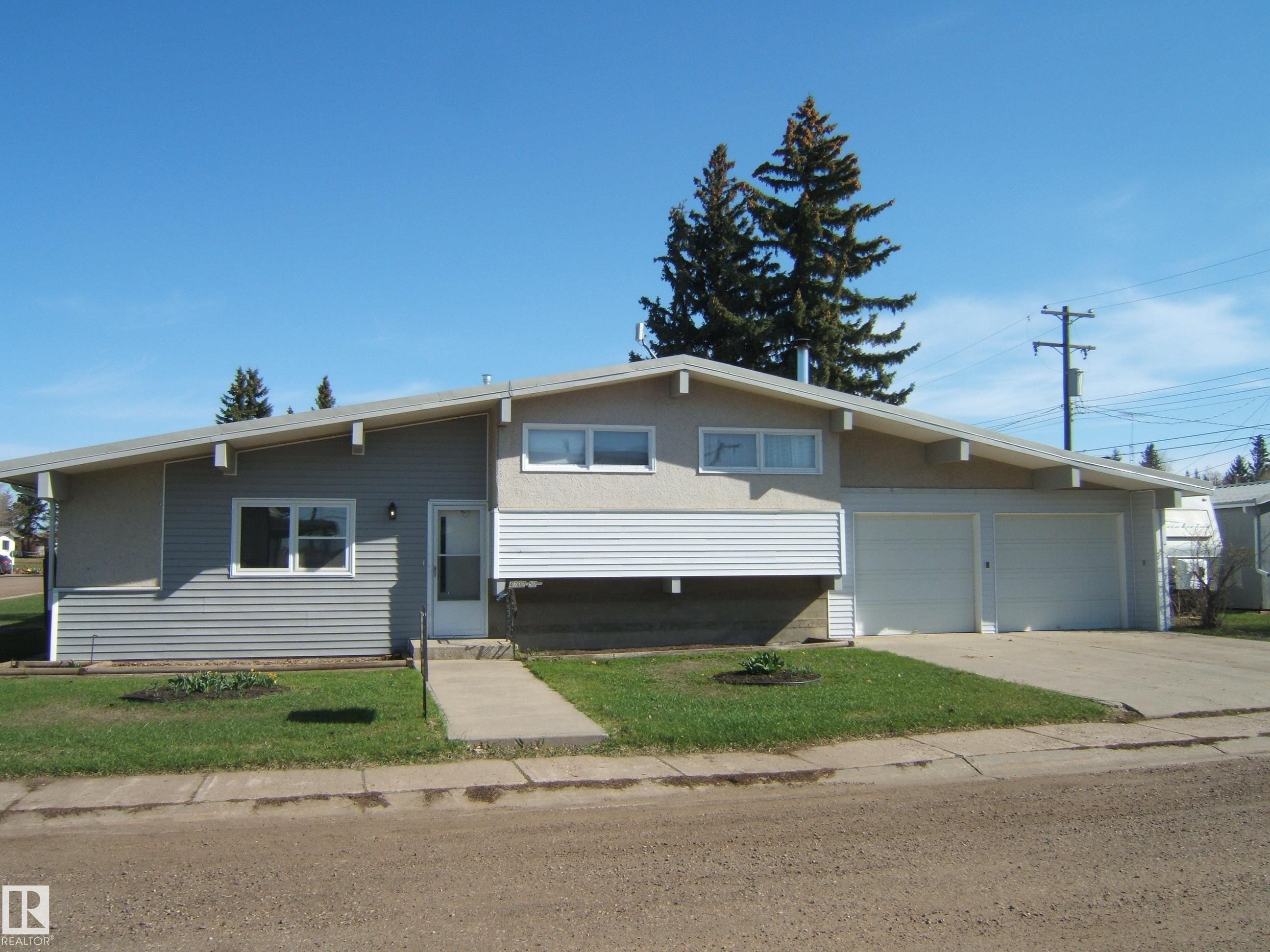 Split-level residence featuring a prominent pitched roofline and an attached two-car garage - 4702 52 Avenue, Two Hills, AB - Outdoor
