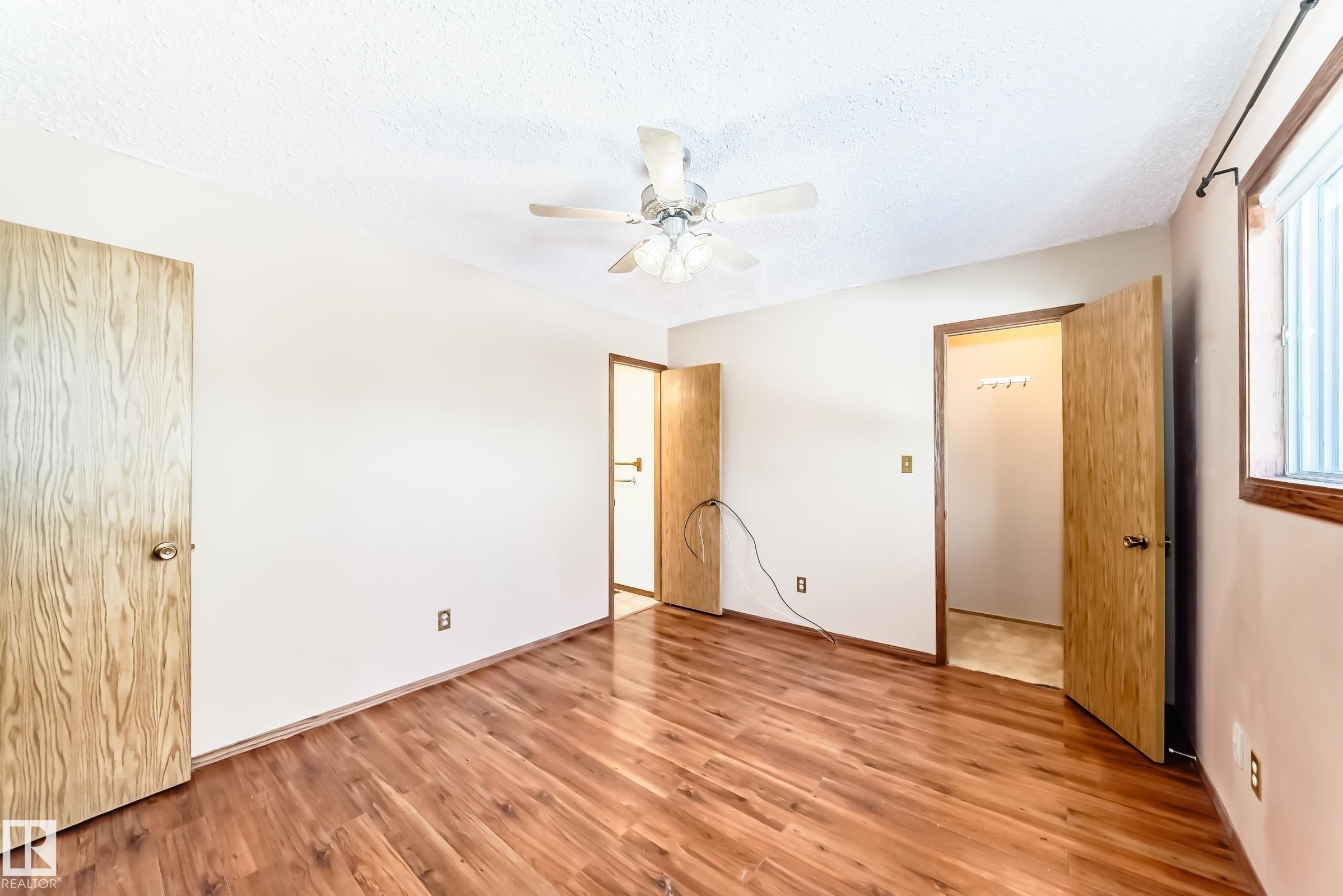 The room features hardwood floors, light-colored walls, and a ceiling fan - 100 23016 Twp Rd 504, Rural Leduc County, AB - Indoor Photo Showing Other Room