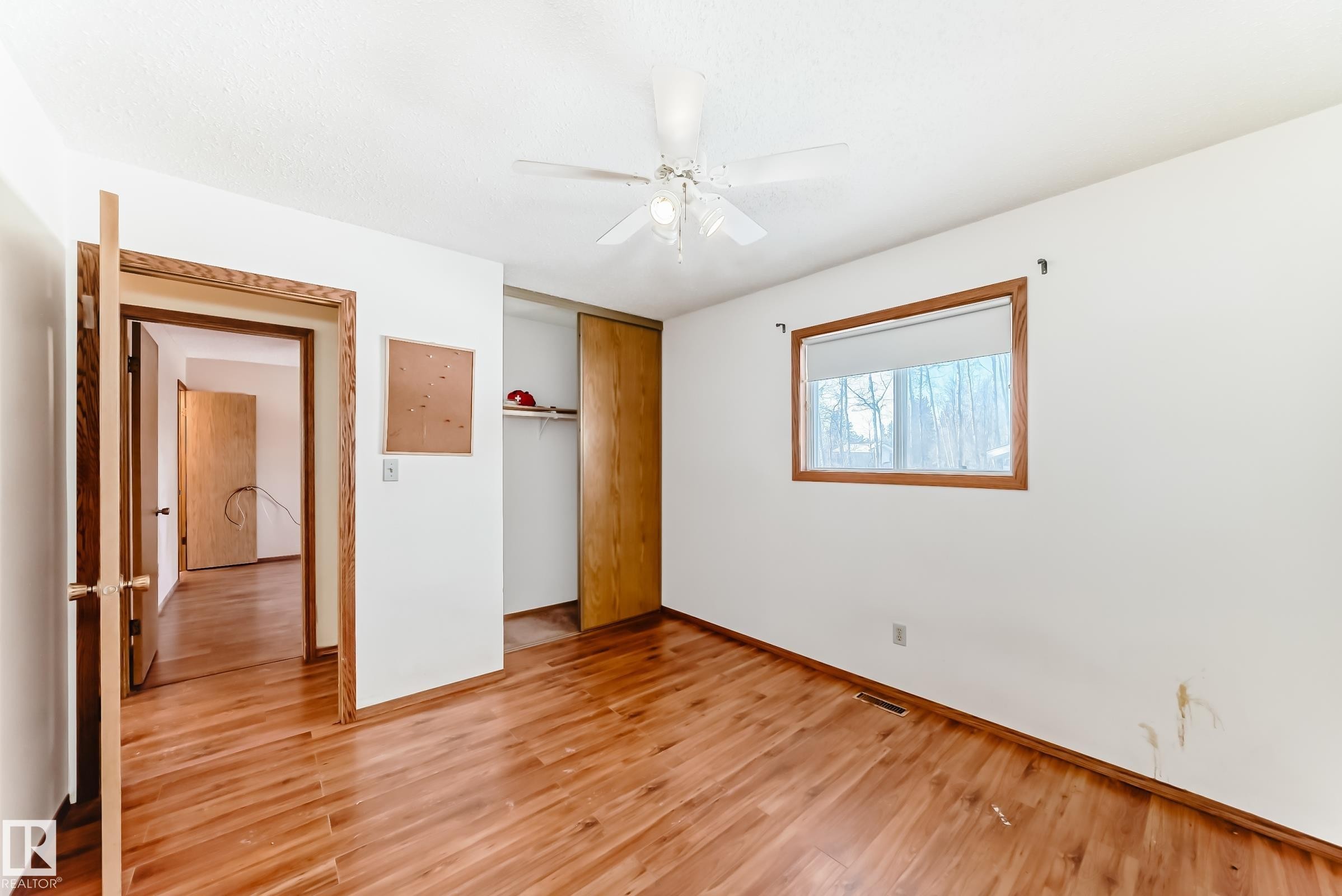 This room features hardwood flooring, a window providing natural light, and a ceiling fan - 100 23016 Twp Rd 504, Rural Leduc County, AB - Indoor Photo Showing Other Room