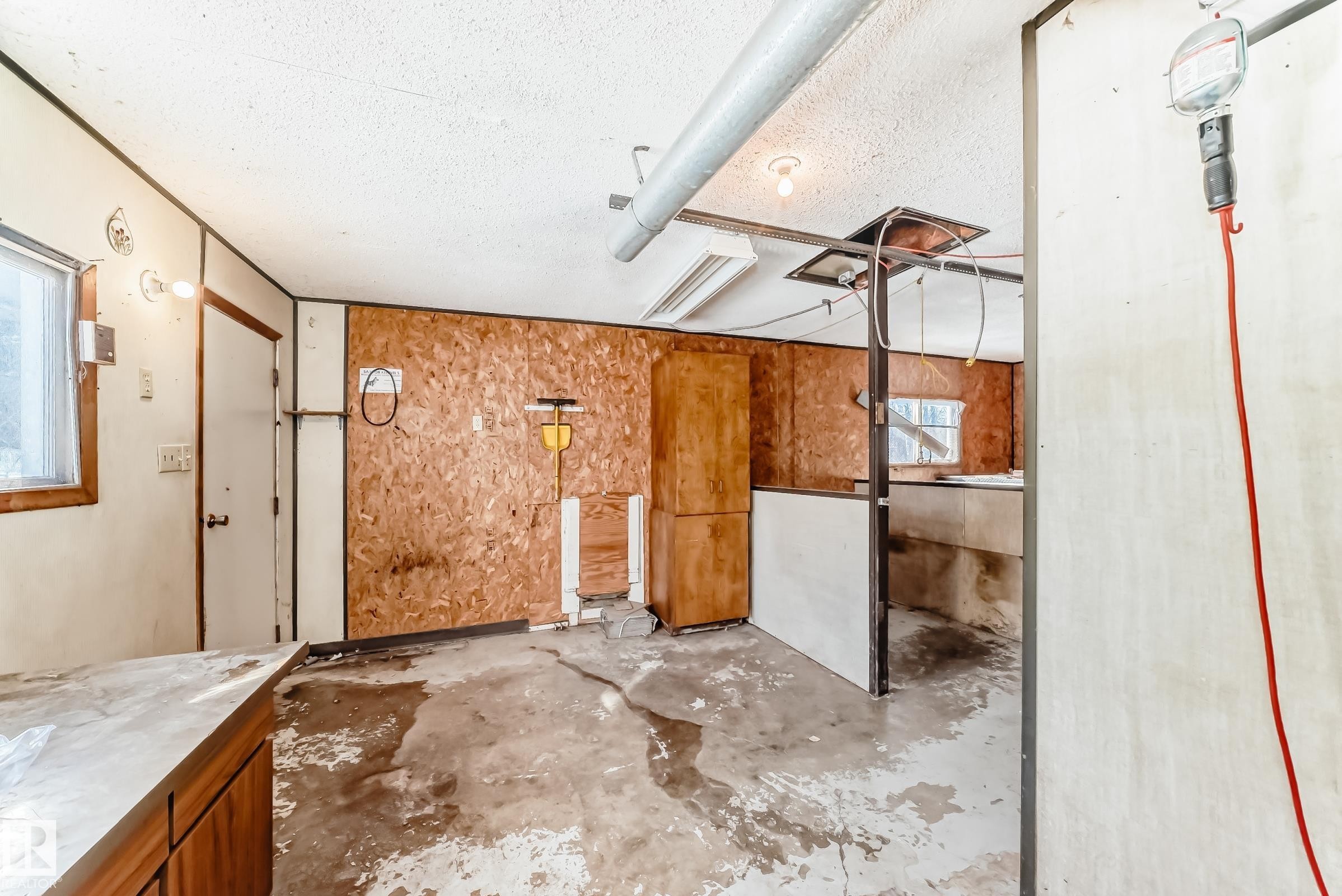 The property features a utility room with exposed plywood walls, a window, and a door - 100 23016 Twp Rd 504, Rural Leduc County, AB - Indoor