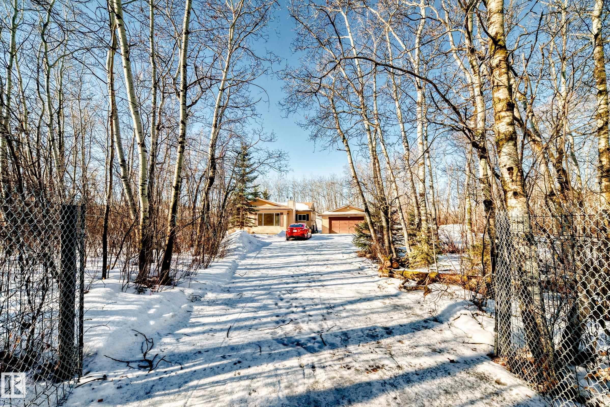 The property features a private driveway leading to a single-story home with an attached garage - 100 23016 Twp Rd 504, Rural Leduc County, AB - Outdoor With View