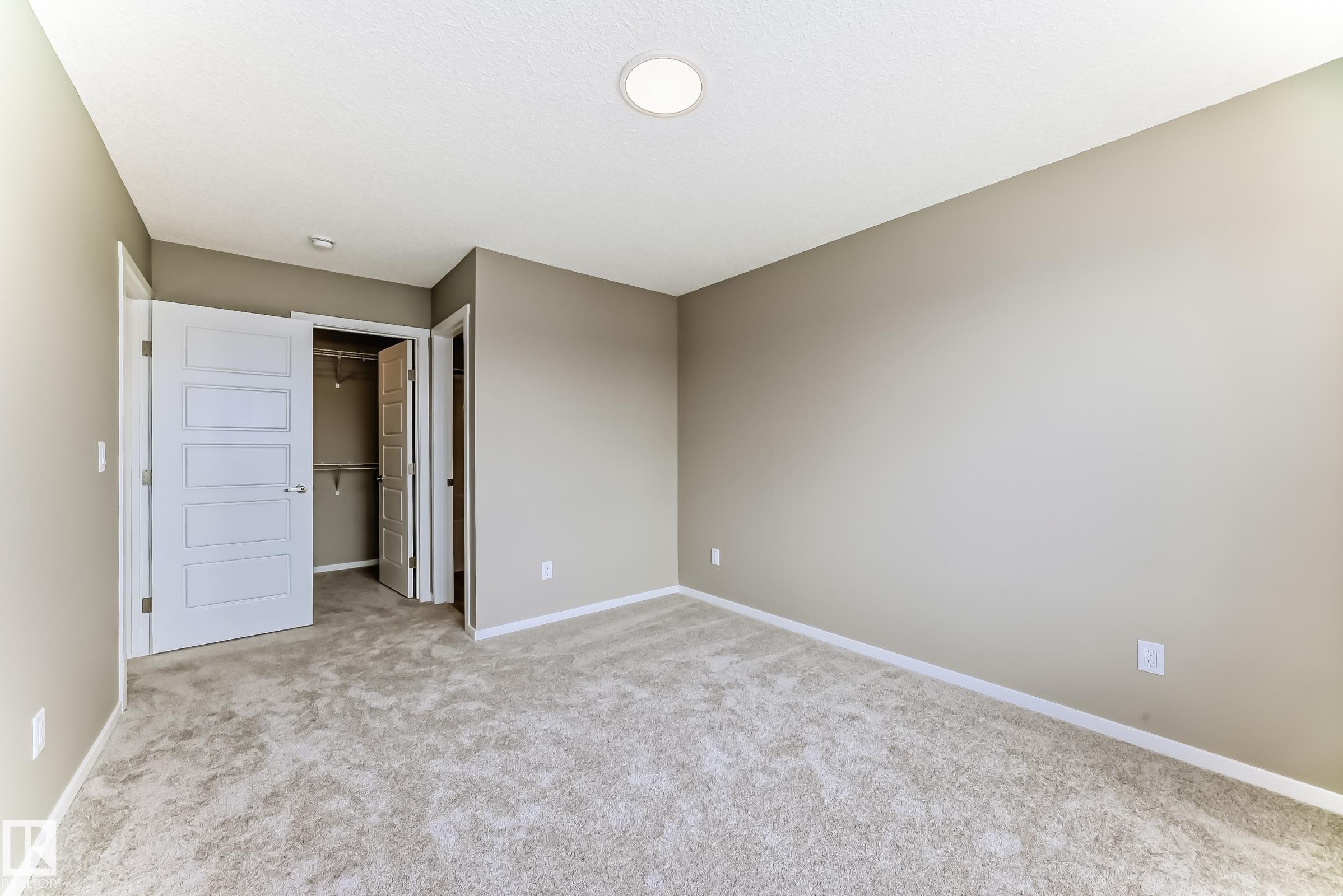 Neutral-toned room featuring a light-colored carpet, recessed ceiling lighting, and white baseboards - 20415 16 Avenue, Edmonton, AB