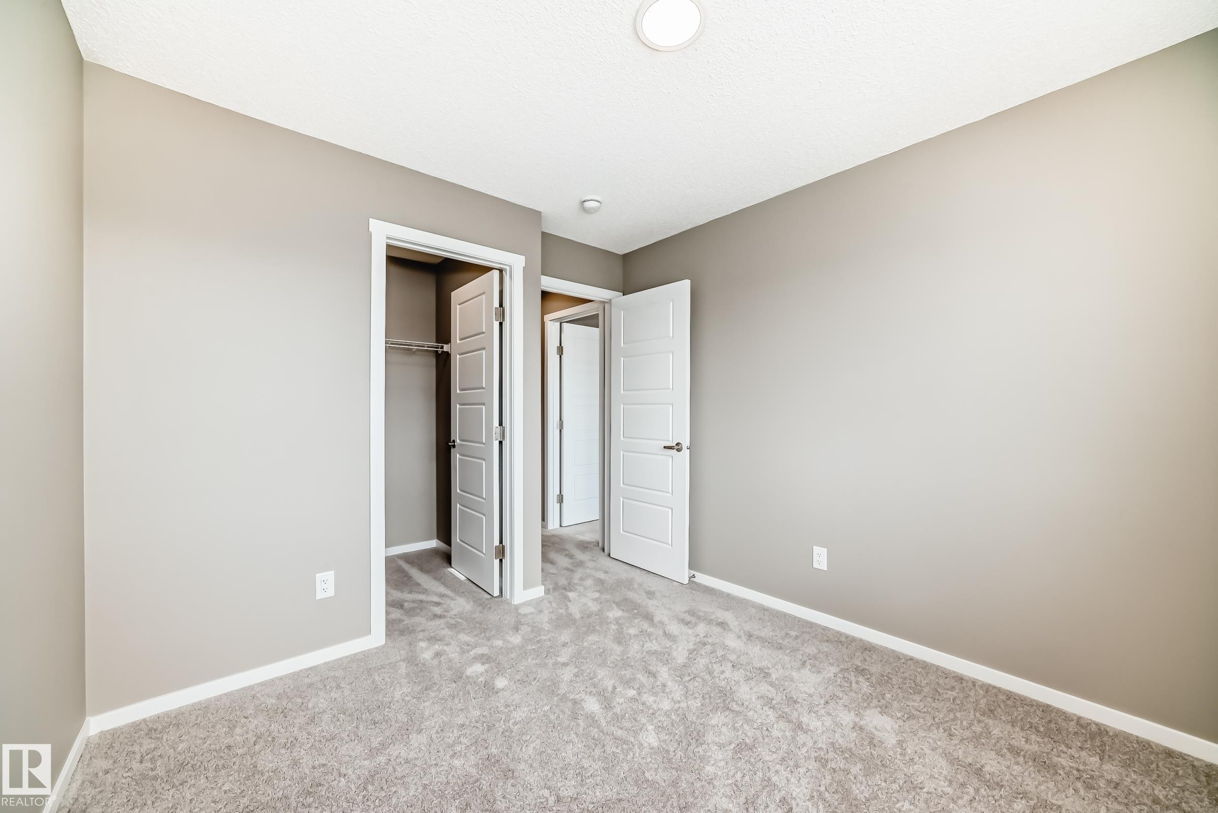 Neutral-toned room featuring light gray carpet flooring and painted walls - 20415 16 Avenue, Edmonton, AB