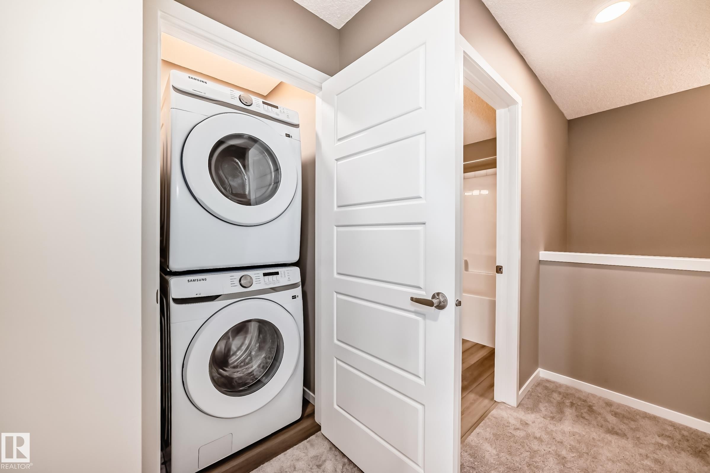 Dedicated laundry closet featuring a stacked washer and dryer - 20415 16 Avenue, Edmonton, AB