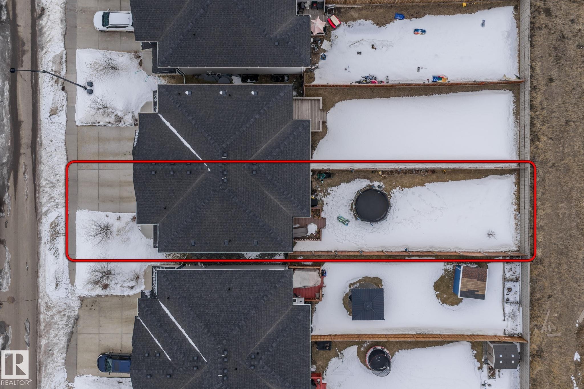 Aerial view of the property, featuring a roof with dark shingles and a paved driveway - 483 Ebbers Way Nw, Edmonton, AB -