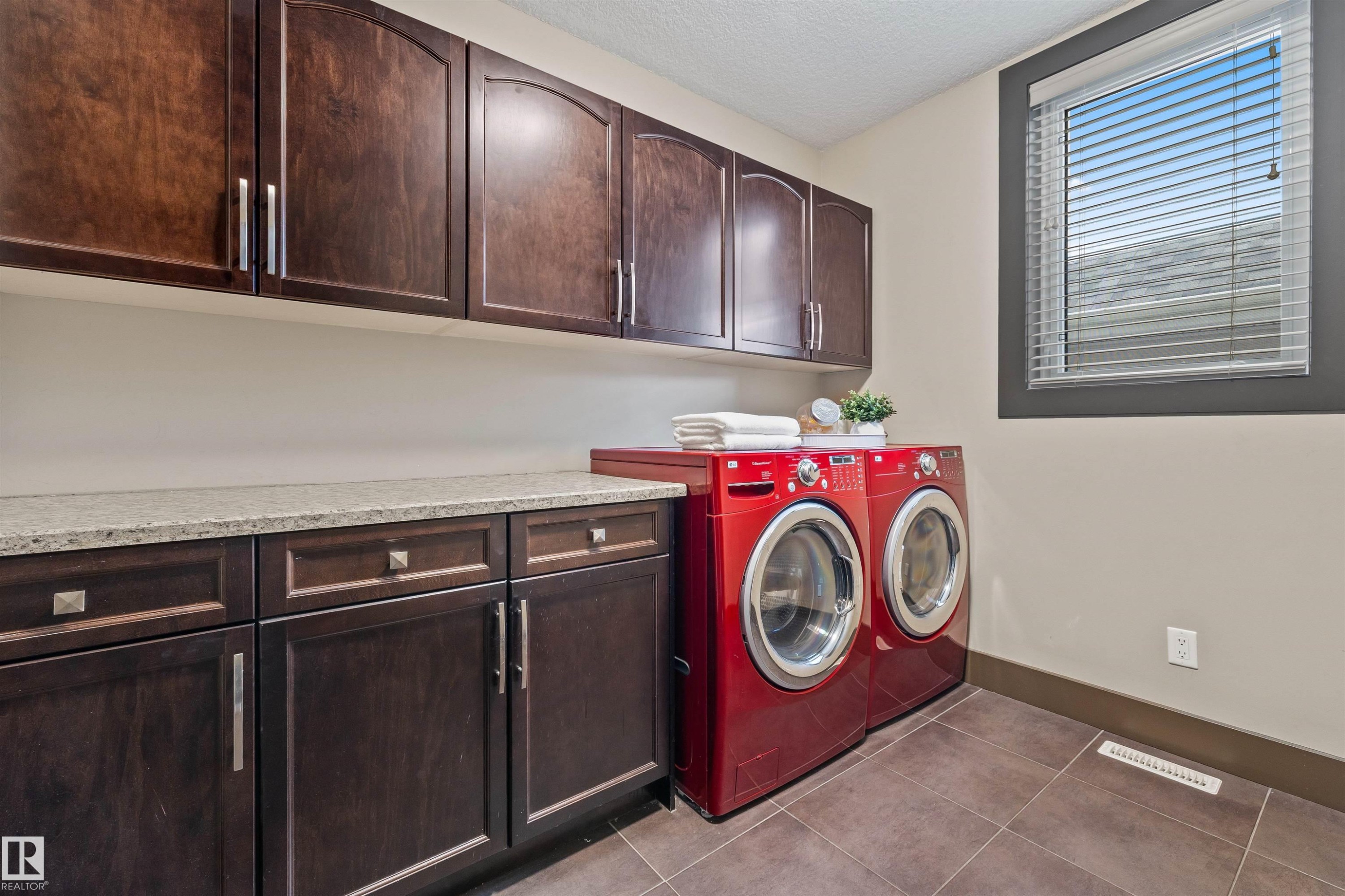 Laundry room featuring dark wood cabinetry, a light-colored countertop, and a window with horizontal blinds - 1014 Hope Road, Edmonton, AB - Indoor Photo Showing Laundry Room