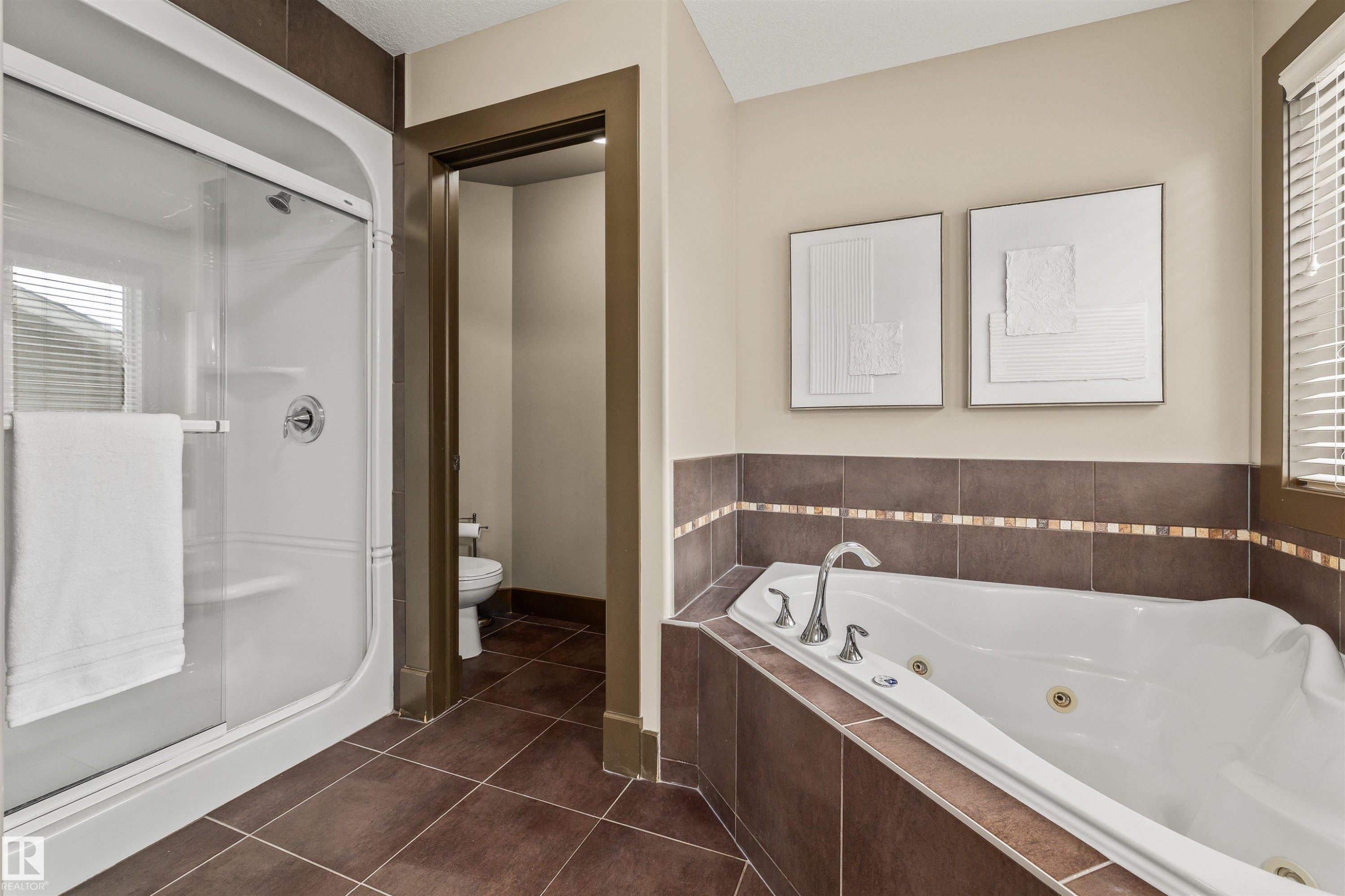 This primary bathroom features a spacious soaking tub with jets, a separate shower enclosure, and tiled flooring - 1014 Hope Road, Edmonton, AB - Indoor Photo Showing Bathroom