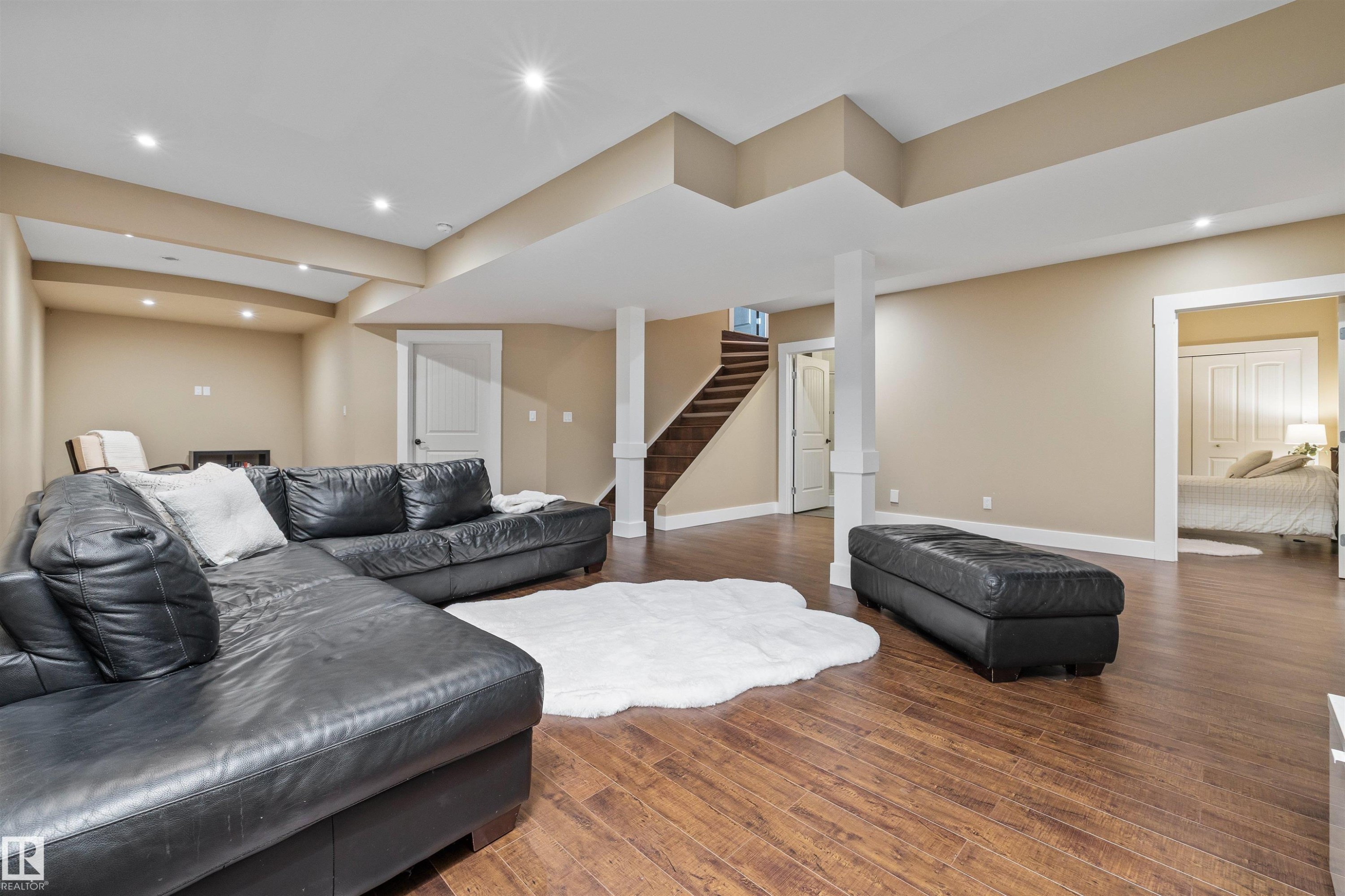 Spacious second living area featuring durable flooring, recessed lighting, and access to a staircase with wood treads - 1014 Hope Road, Edmonton, AB - Indoor Photo Showing Other Room