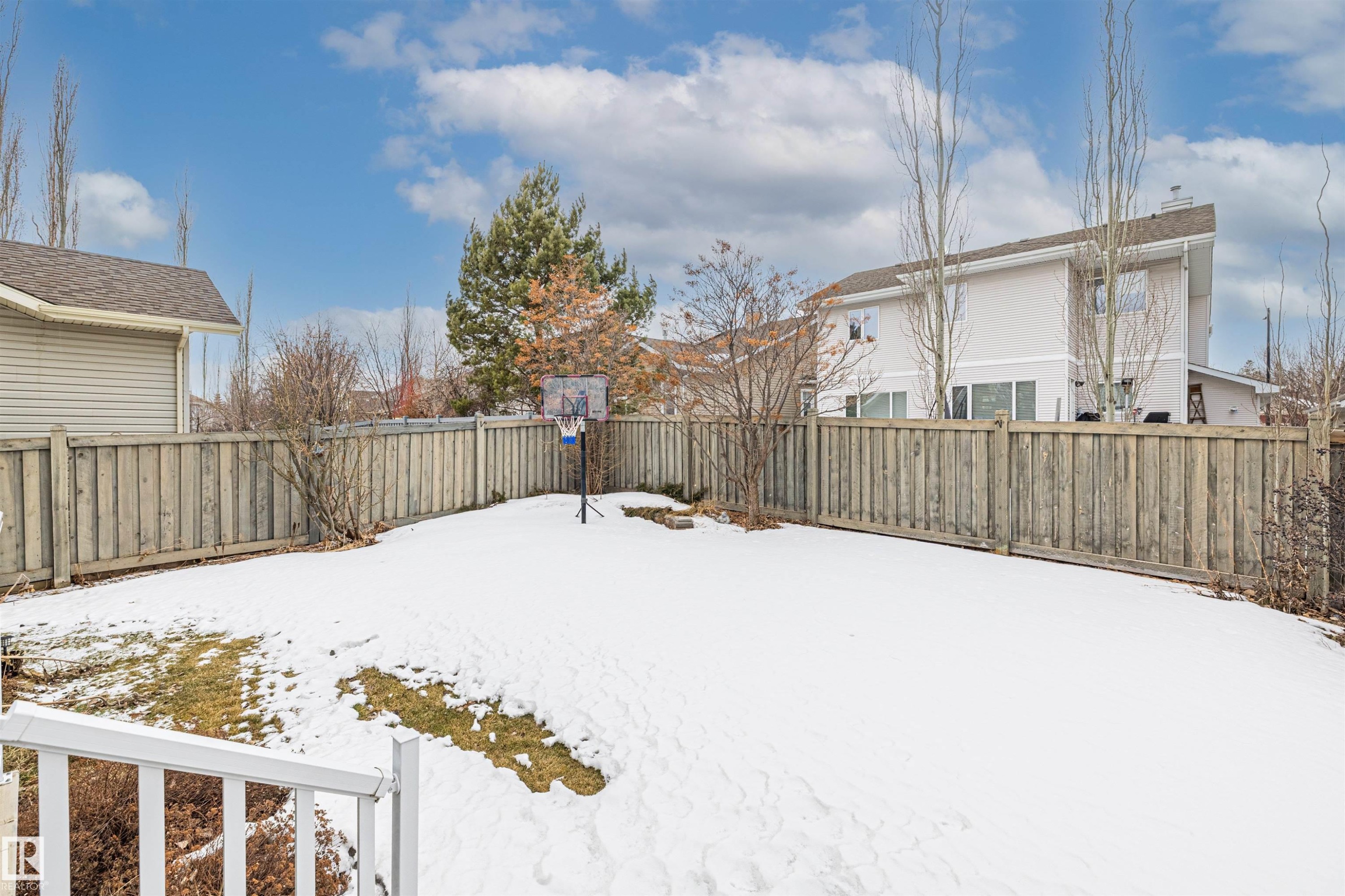 The property features a private yard with a wooden fence and a basketball hoop - 1014 Hope Road, Edmonton, AB - Outdoor