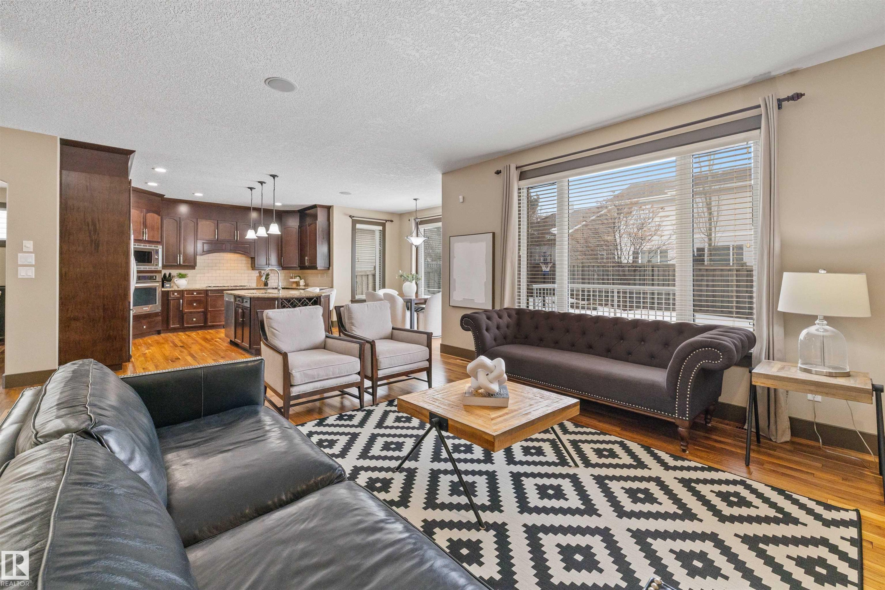 The open-concept living area features hardwood floors, a large window providing natural light, and recessed lighting - 1014 Hope Road, Edmonton, AB - Indoor Photo Showing Living Room