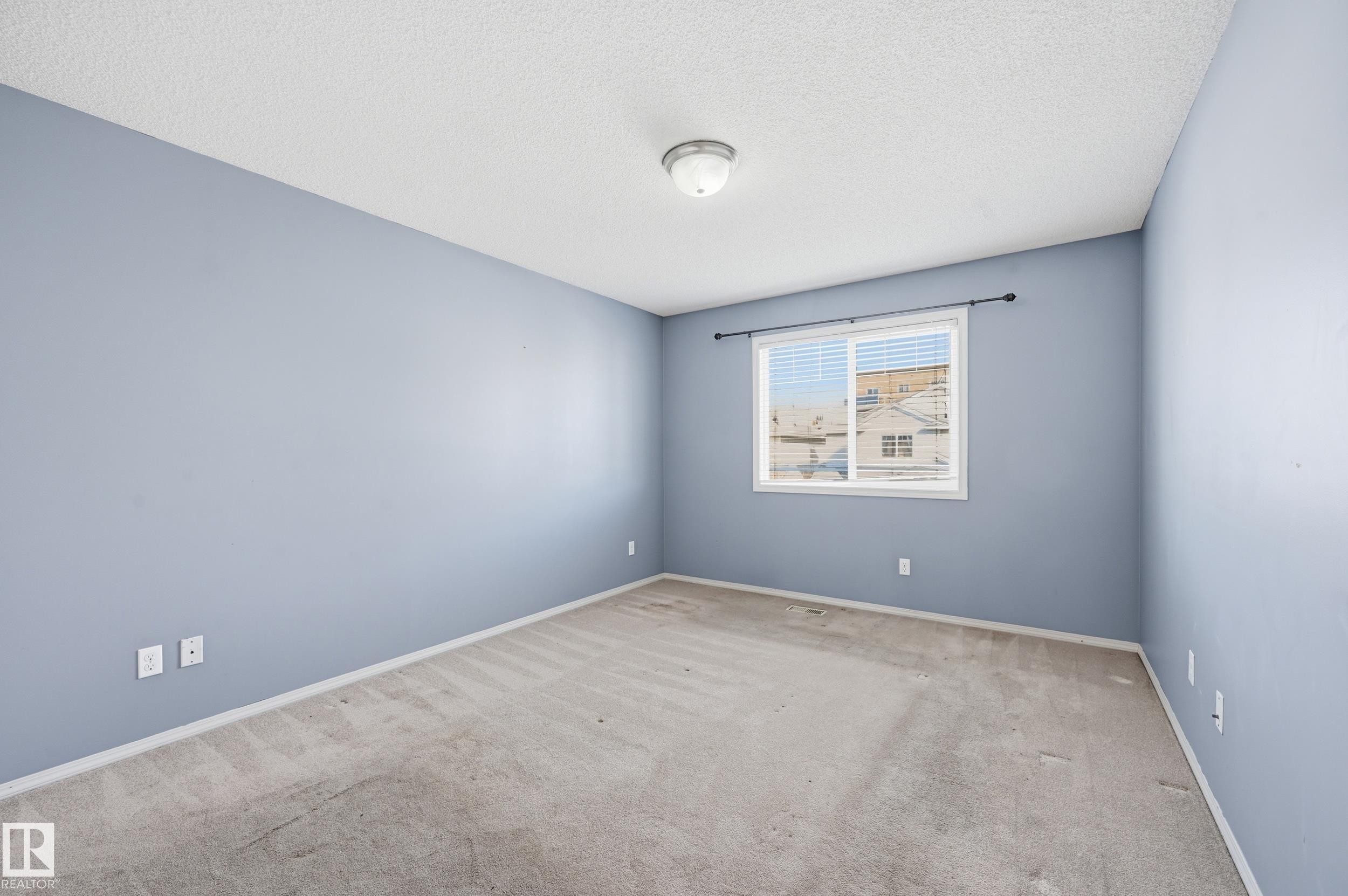 This room features light blue walls, a window with blinds, and carpeted flooring - 53 287 Macewan Road, Edmonton, AB - Indoor Photo Showing Other Room