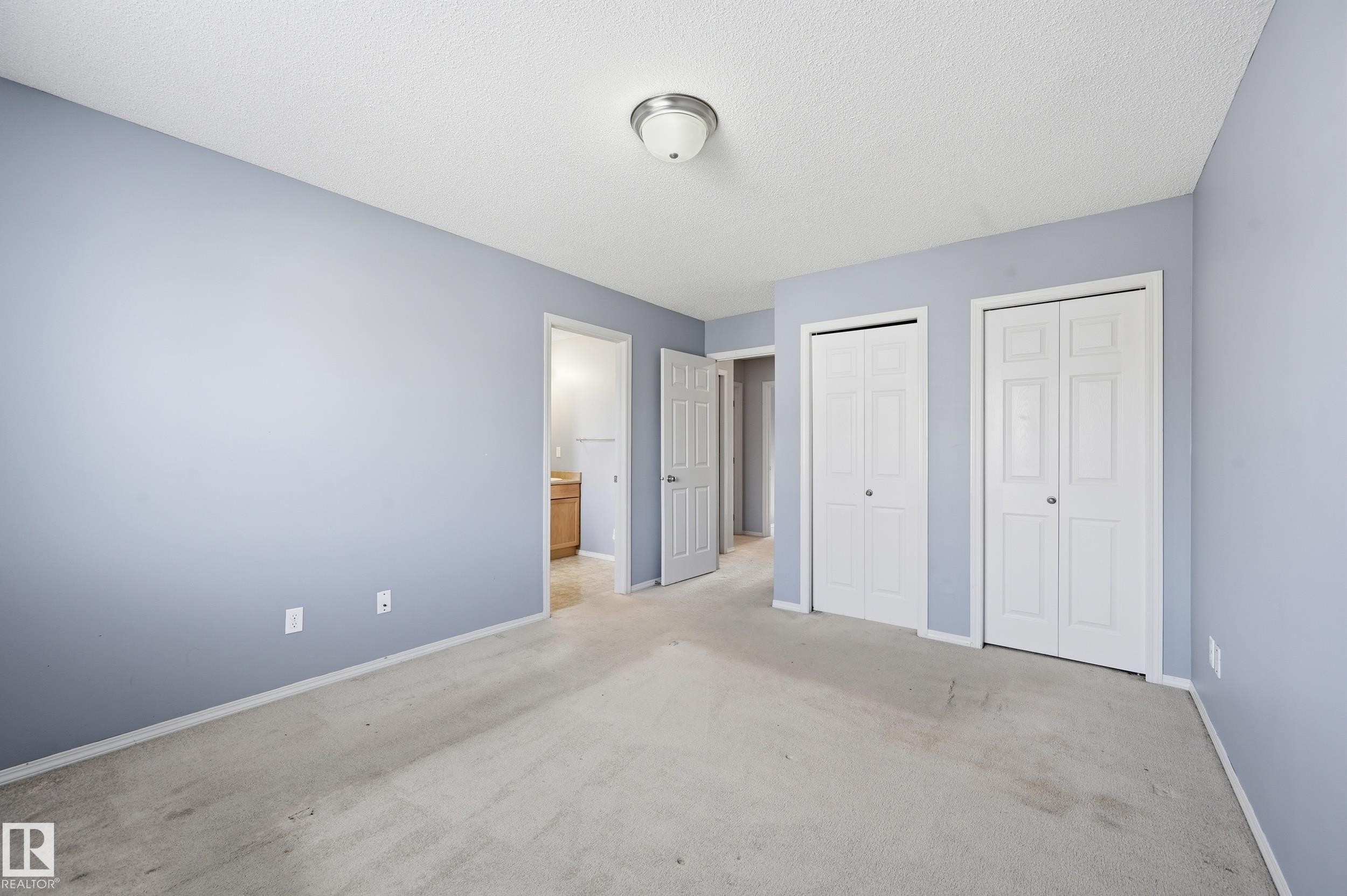 The property features light blue walls and neutral carpeting, creating a serene ambiance - 53 287 Macewan Road, Edmonton, AB - Indoor