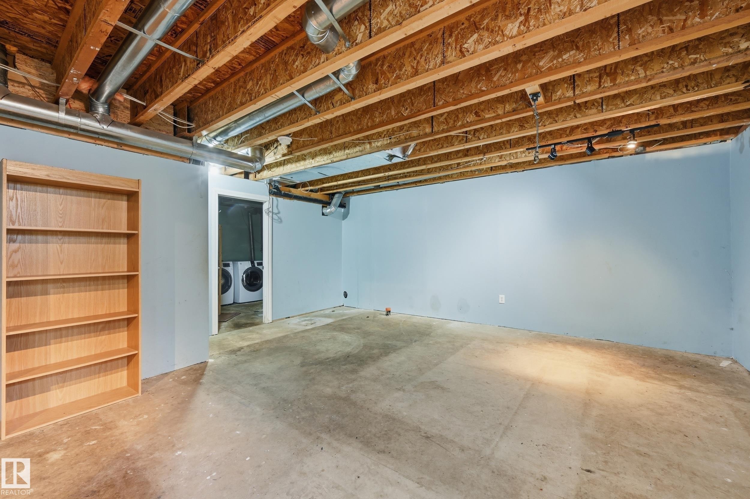 The property features an unfinished basement with exposed wooden joists and ductwork, painted walls, and a concrete floor - 53 287 Macewan Road, Edmonton, AB - Indoor Photo Showing Basement